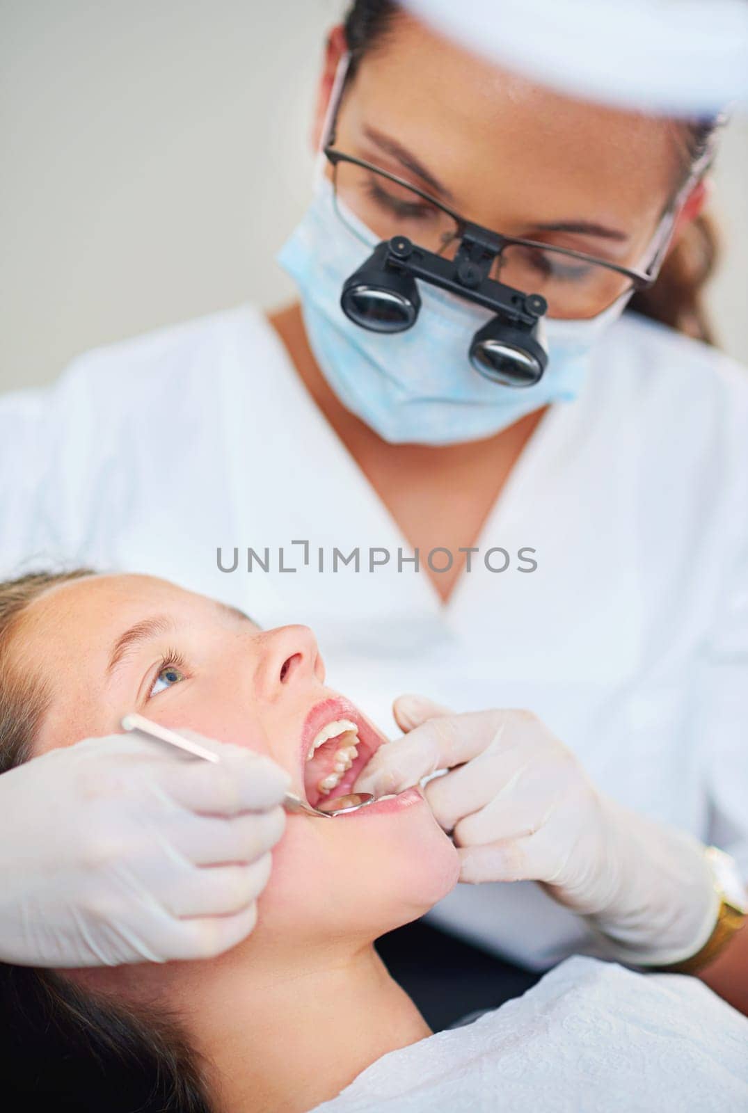 Open wide...a female dentist and child in a dentist office. by YuriArcurs