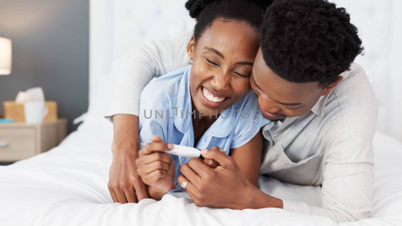 African couple, pregnancy test and planning for baby together in home, talking about happy news on bed and conversation about child in bedroom. Start of family for man and woman in marriage at house by YuriArcurs