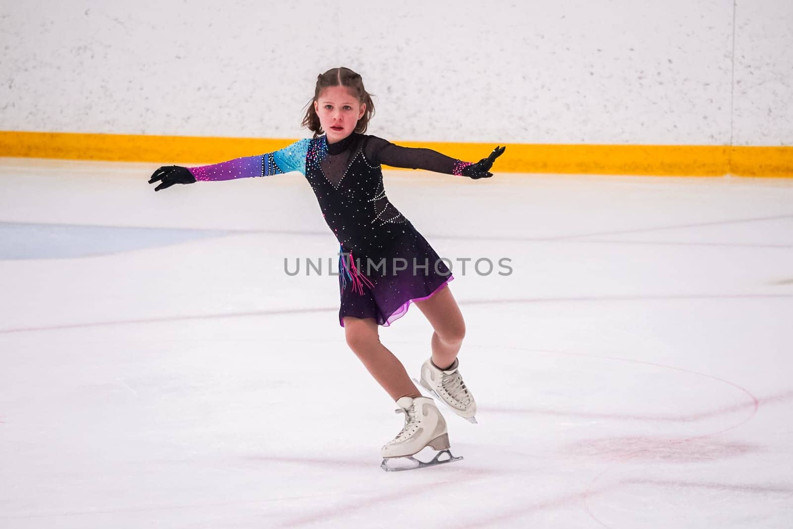 Little girl practicing before her figure skating competition at the indoor ice rink.