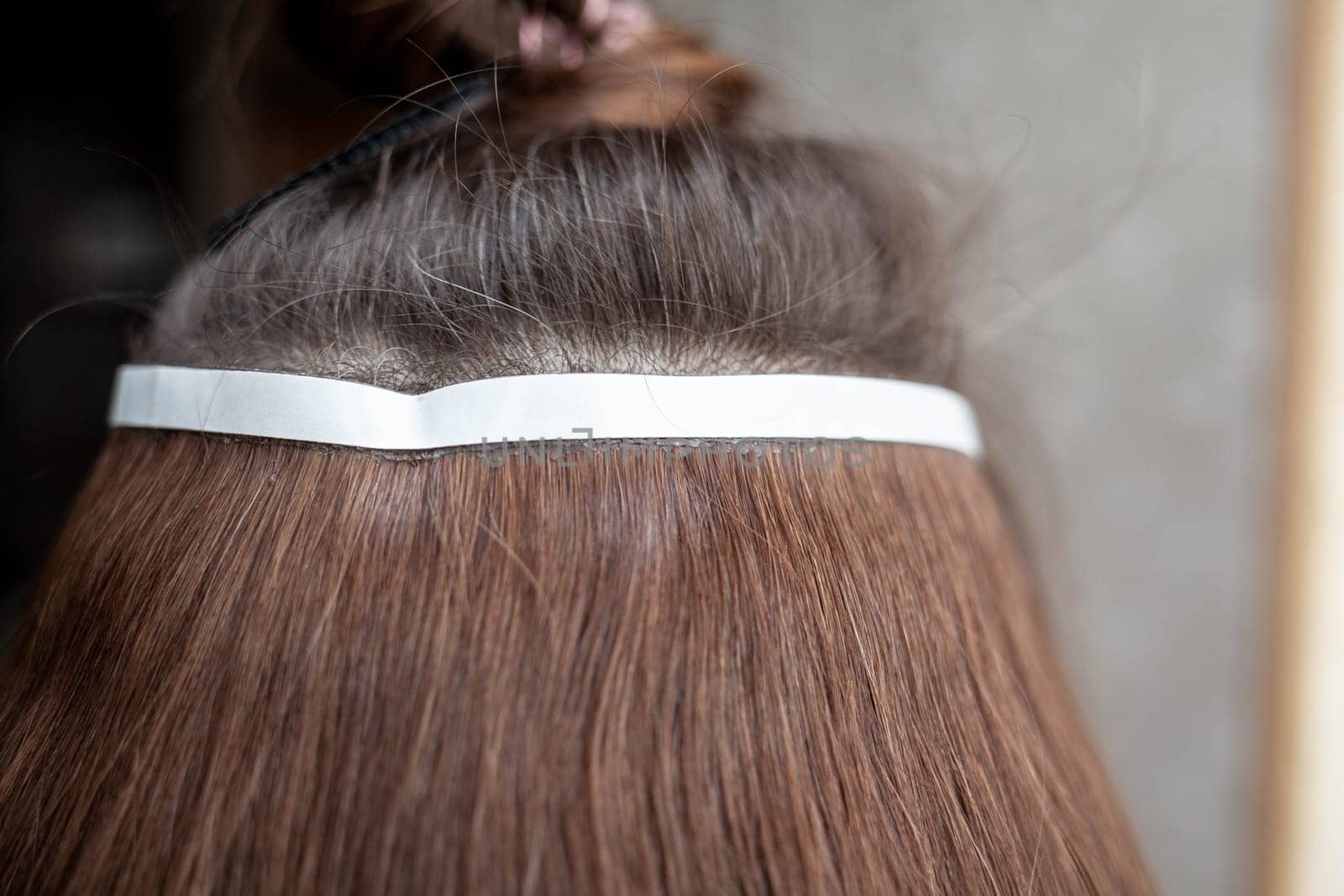 Hair ribbons for extensions on a woman's head at home. by AnatoliiFoto