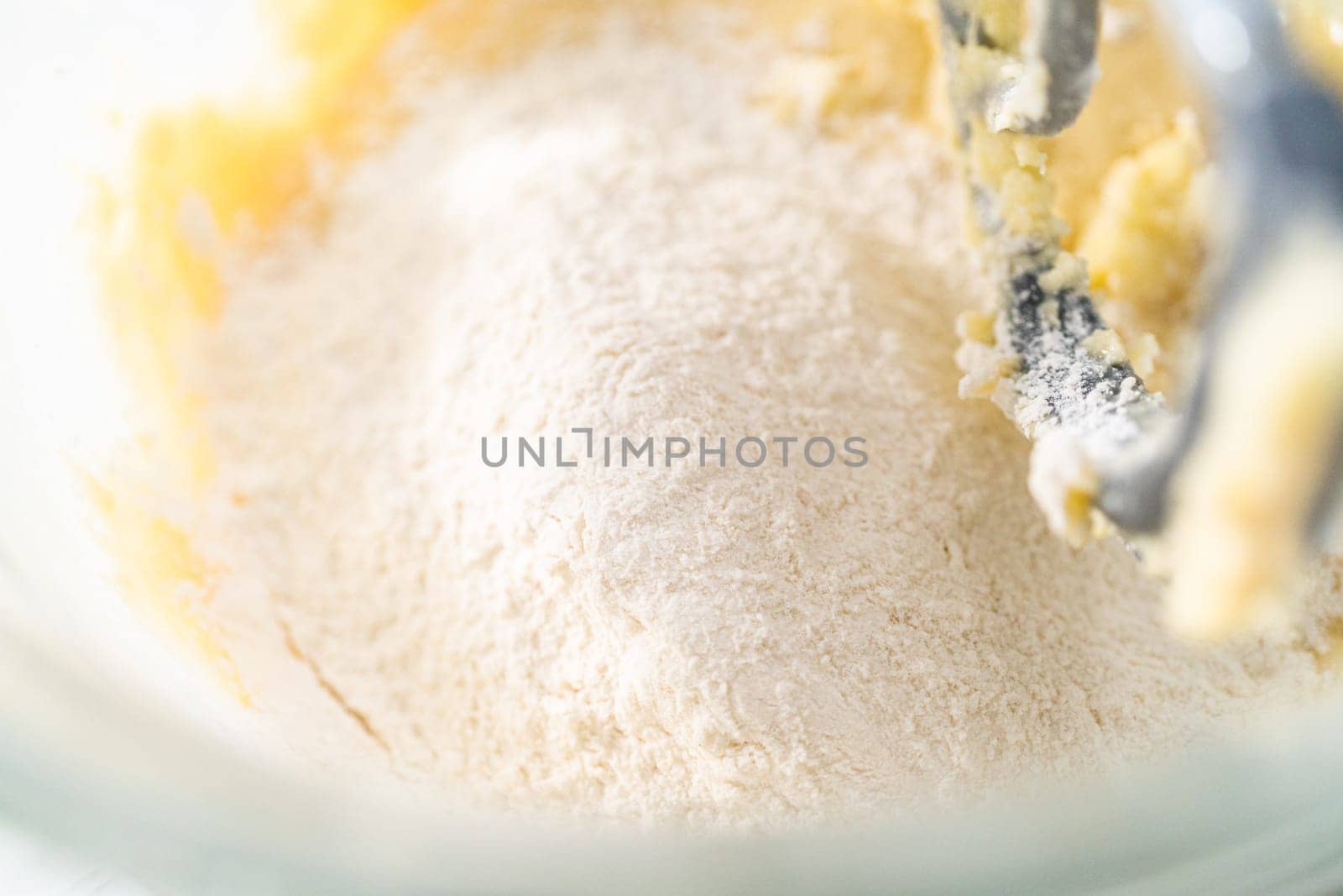 Mixing ingredients in kitchen electric mixer to bake American flag mini cupcakes.