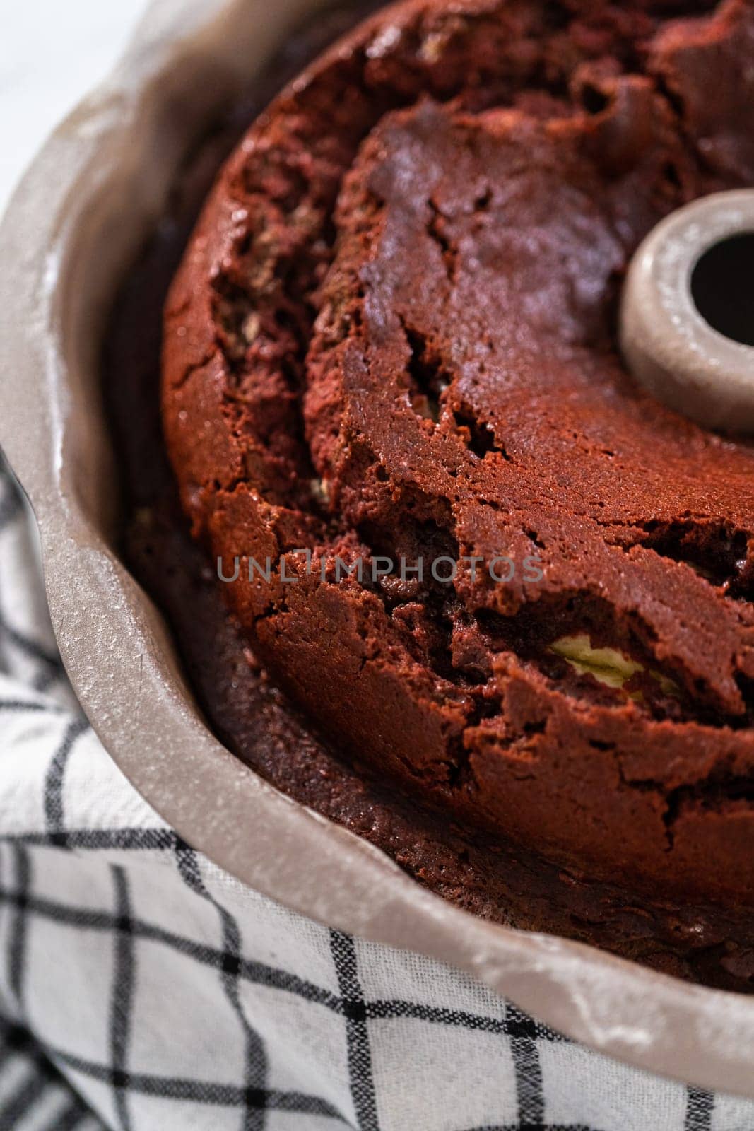 Cooling freshly baked red velvet bundt cake on a kitchen counter.