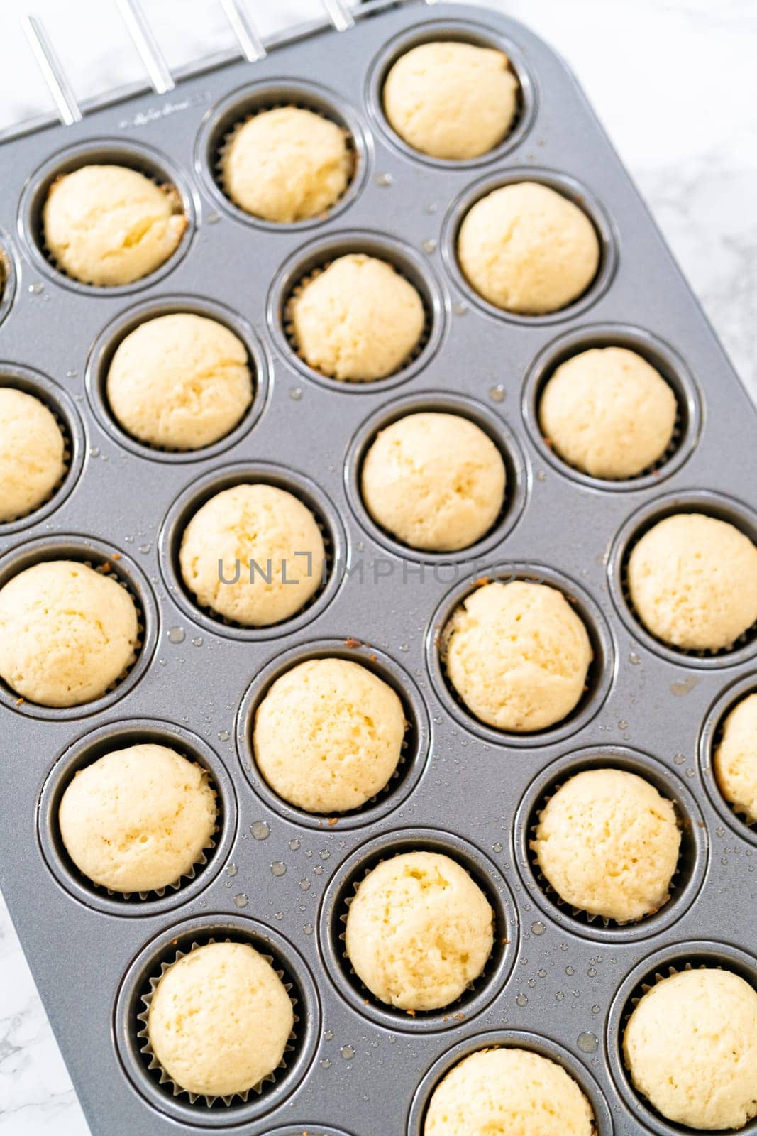 Cooling freshly baked American flag mini cupcakes on a kitchen counter.