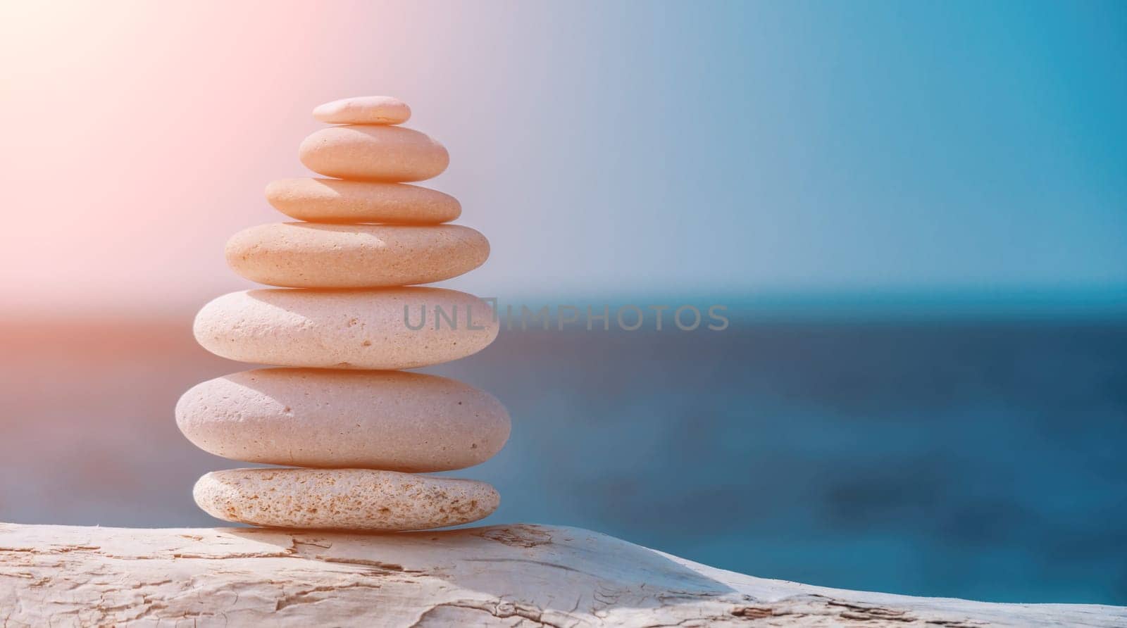 Pyramid stones on the seashore on a sunny day on the blue sea background. Happy holidays. Pebble beach, calm sea, travel destination. Concept of happy vacation on the sea, meditation, spa, calmness. by panophotograph