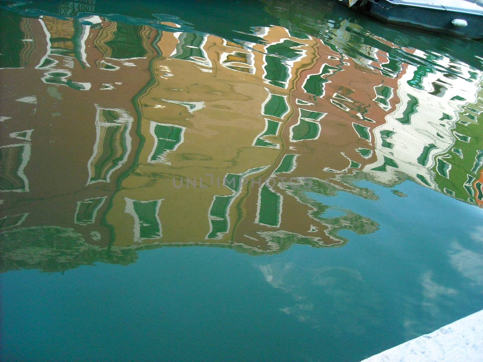 The characteristic colored houses of Burano (Venice) reflected on the water of a canal