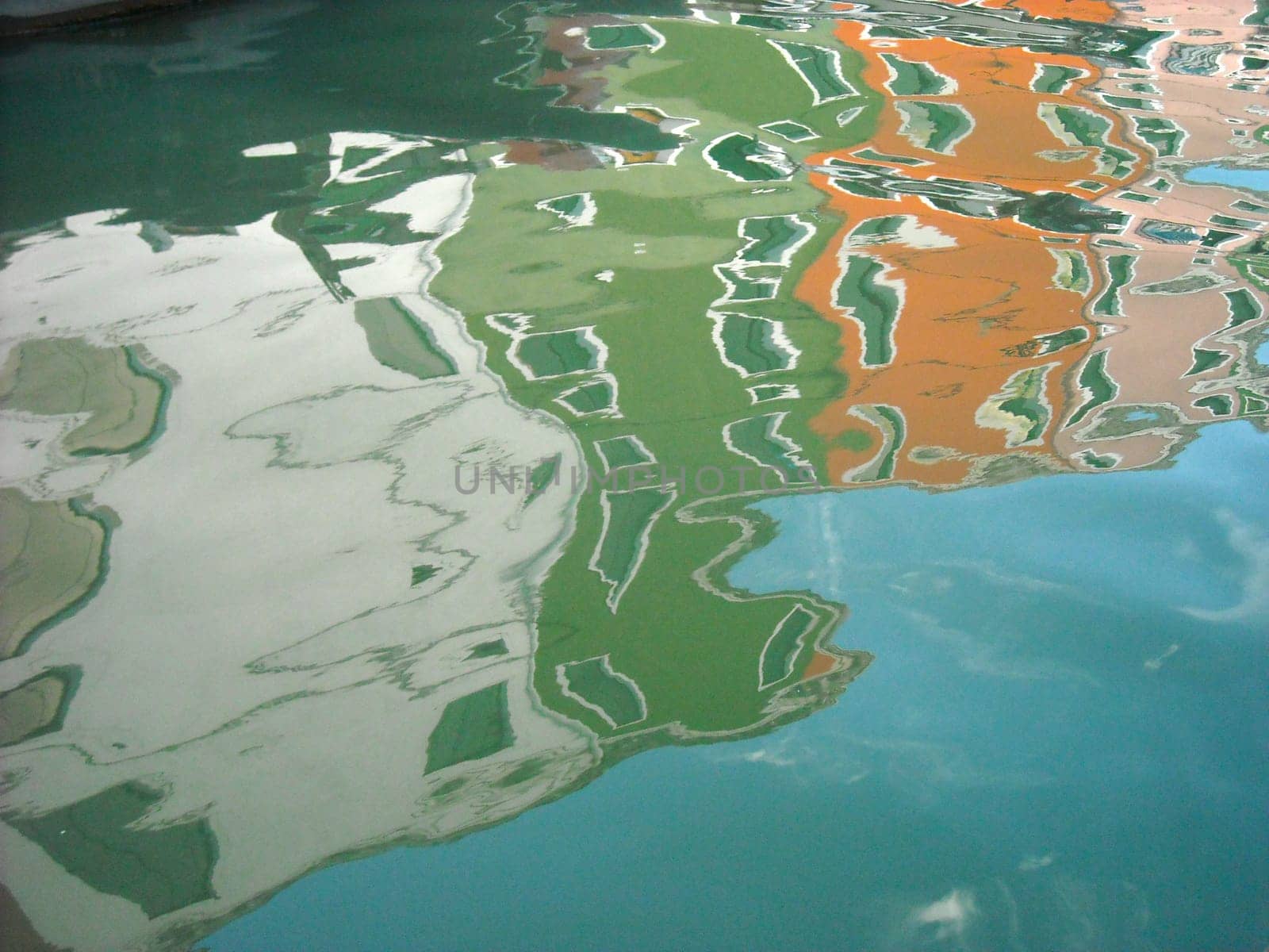 The characteristic colored houses of Burano (Venice) reflected on the water of a canal