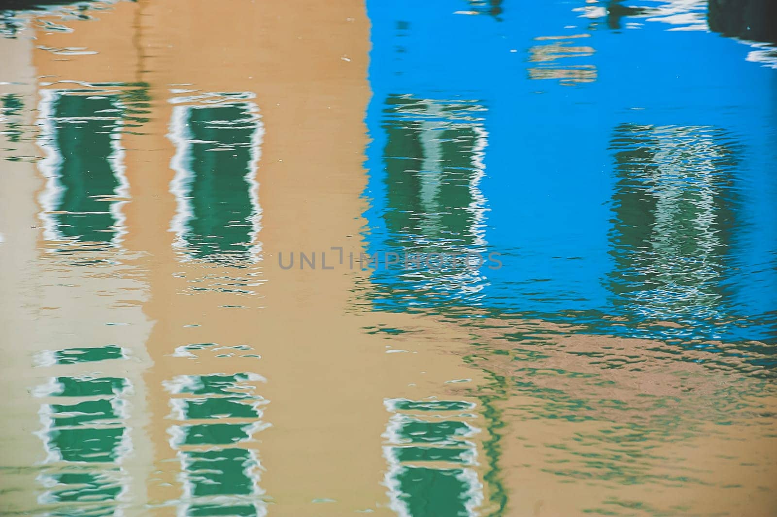 The characteristic colored houses of Burano (Venice) reflected on the water of a canal