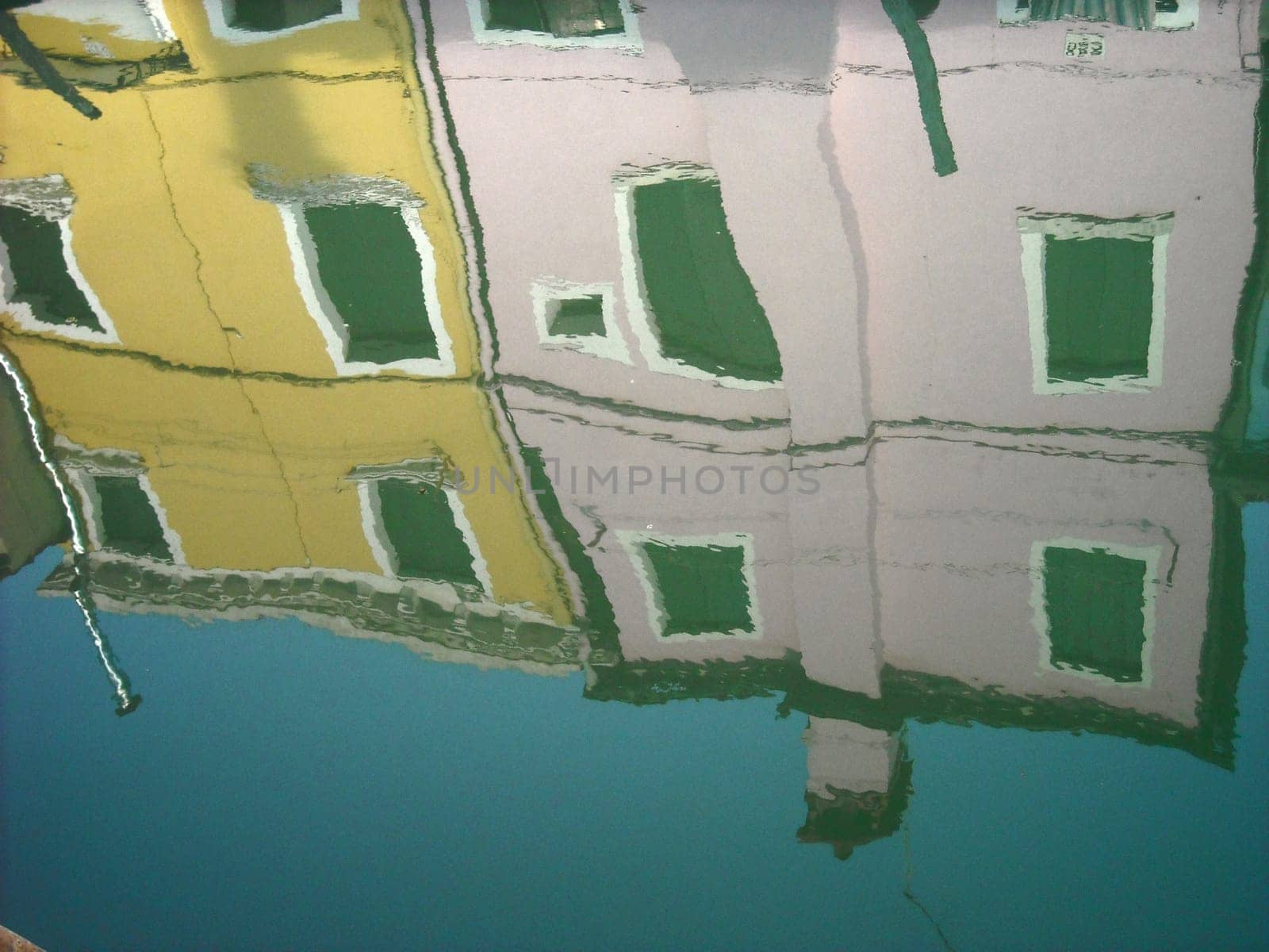 The characteristic colored houses of Burano (Venice) reflected on the water of a canal