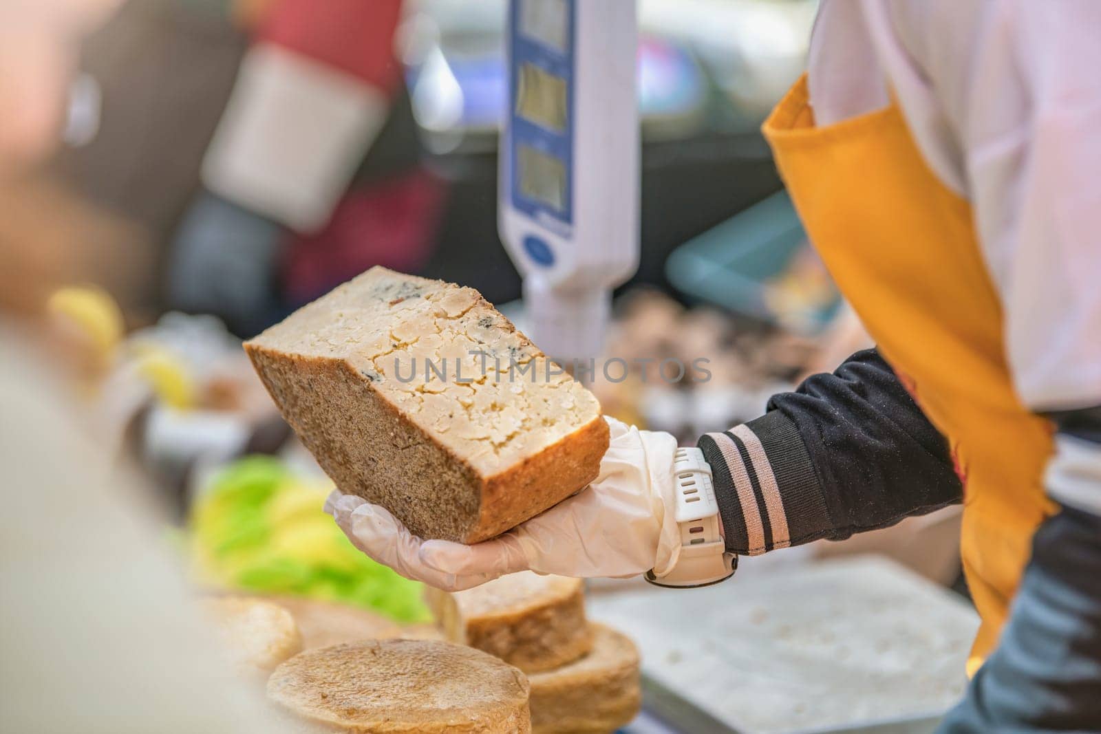 A man gives a cheese tasting to his customer. Cheese tasting. Cheese is cut with a special cheese knife. High quality photo