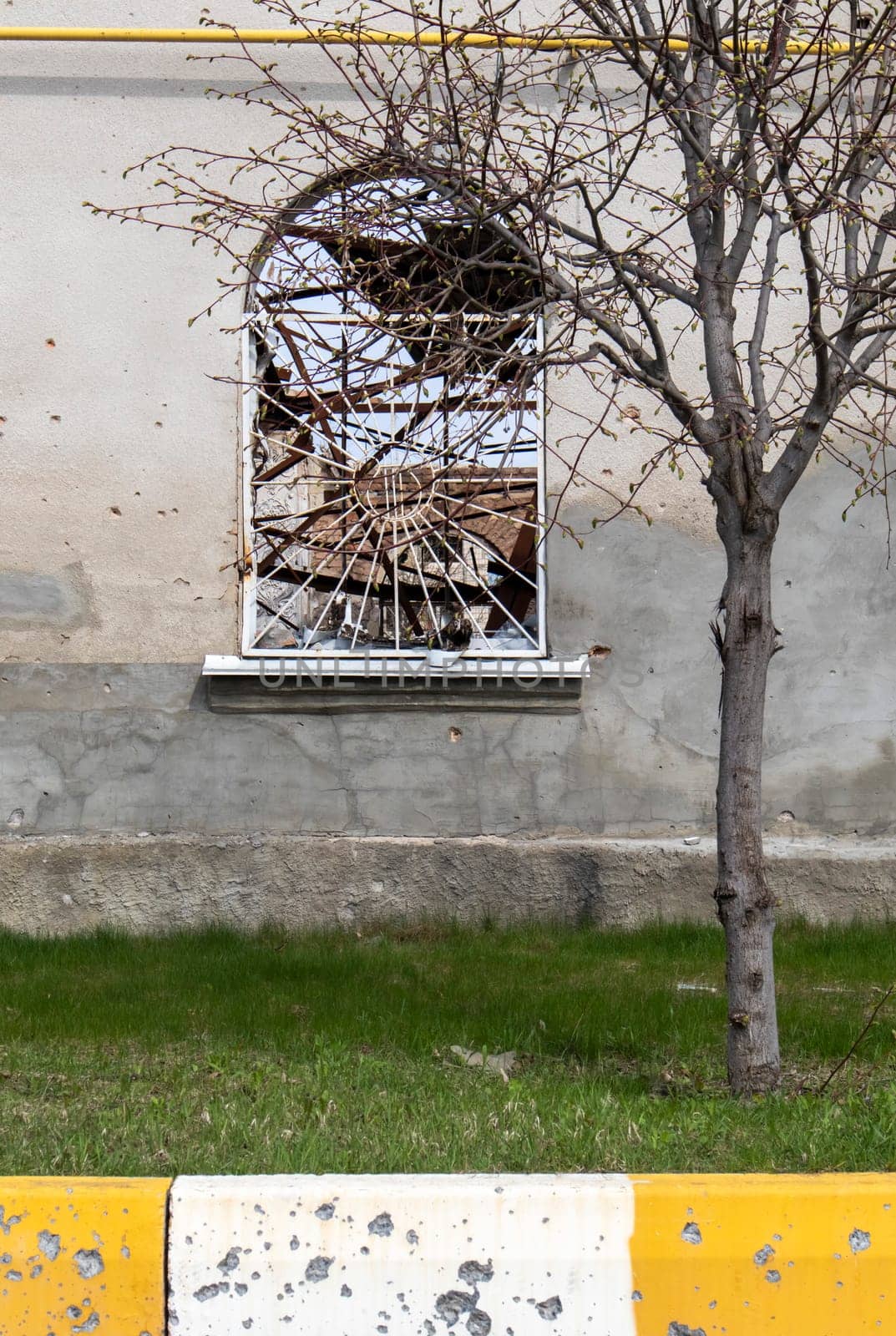 Destroyed and damaged window in the building as a result of the war. The houses were destroyed and burned by artillery during the war. Broken windows. A window destroyed by the fighting