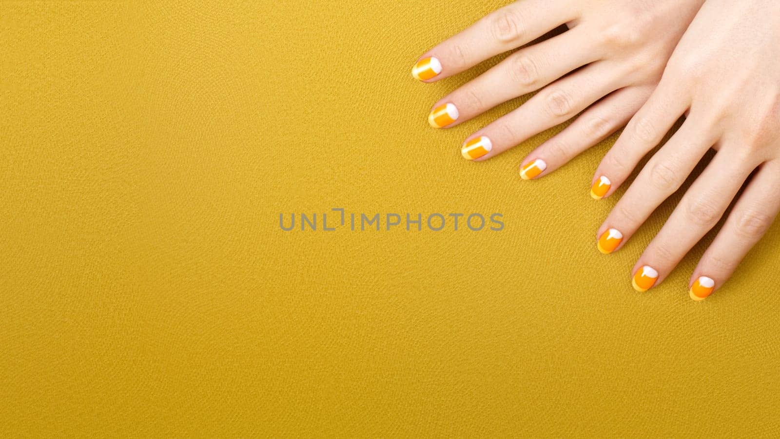 Beautiful Female Hands with bright orange Manicure like Candy Corn. Manicured Nails with Yellow Gel Polish. Halloween Style by MarinaFrost