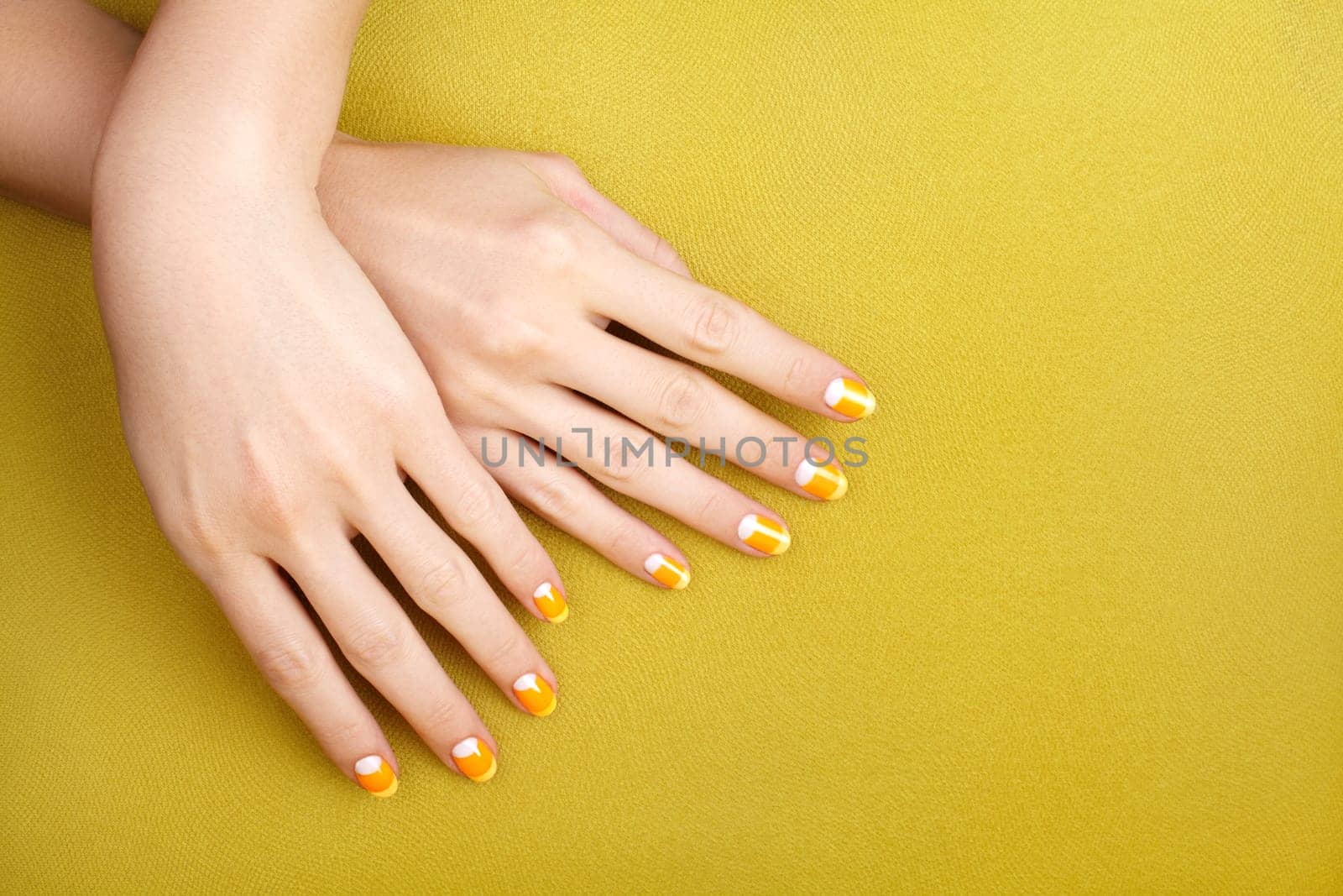 Beautiful Female Hands with bright orange Manicure like Candy Corn. Manicured Nails with Yellow Gel Polish. Halloween Style by MarinaFrost