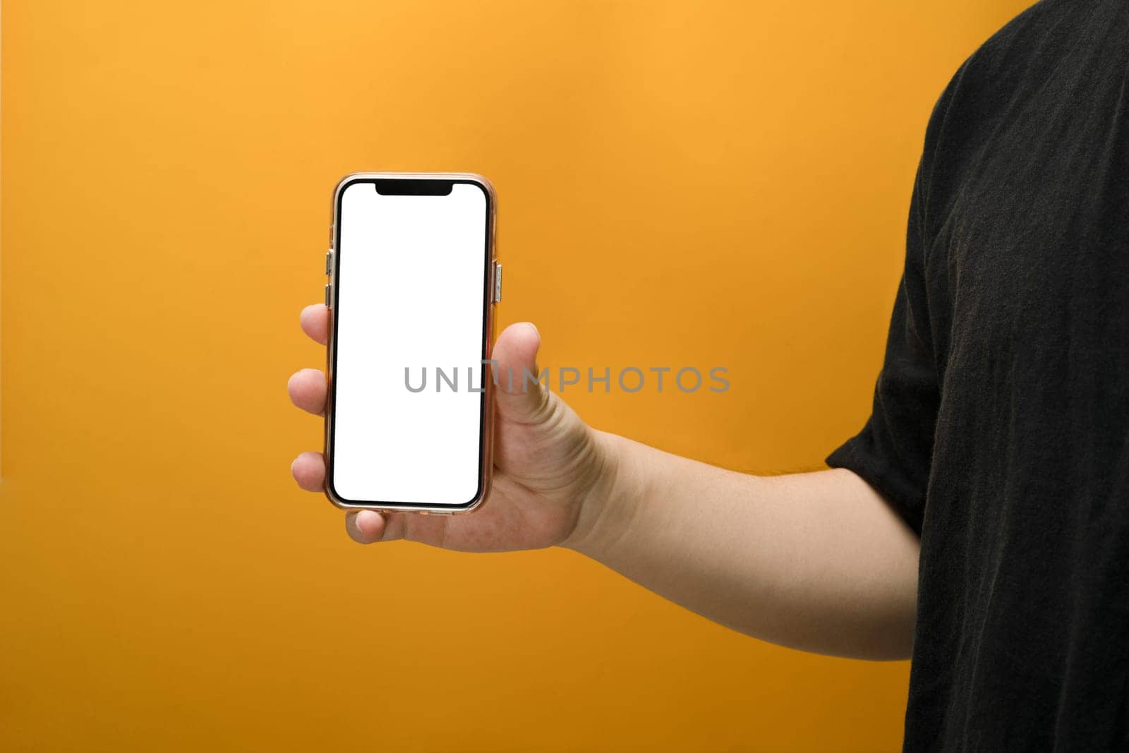 Hand holding smartphone isolated on yellow background. Empty screen for your text message or application design.