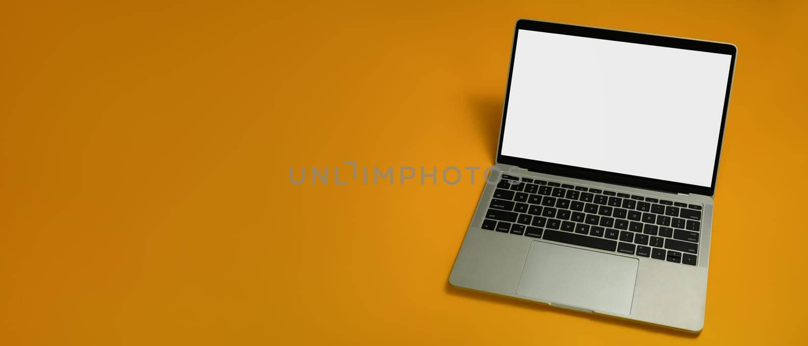 Laptop with white empty screen on yellow background with copy space for your advertise text.