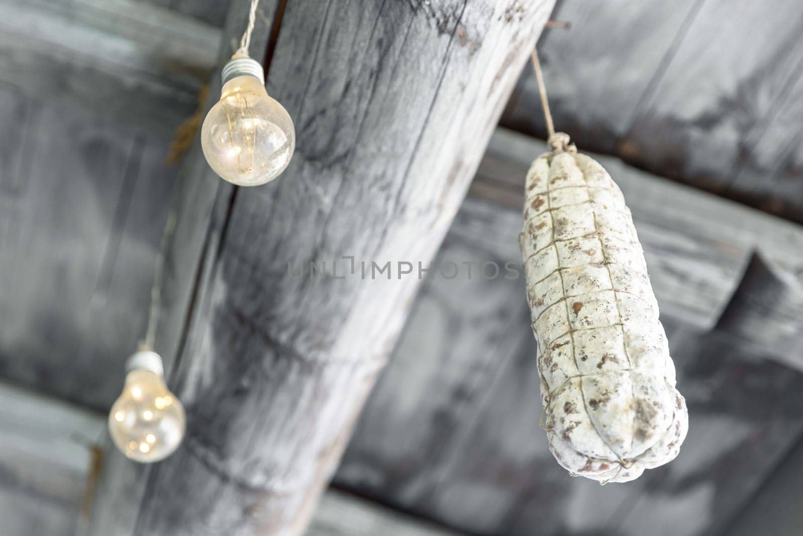 Smoked salami hanging on a hook under the ceiling.