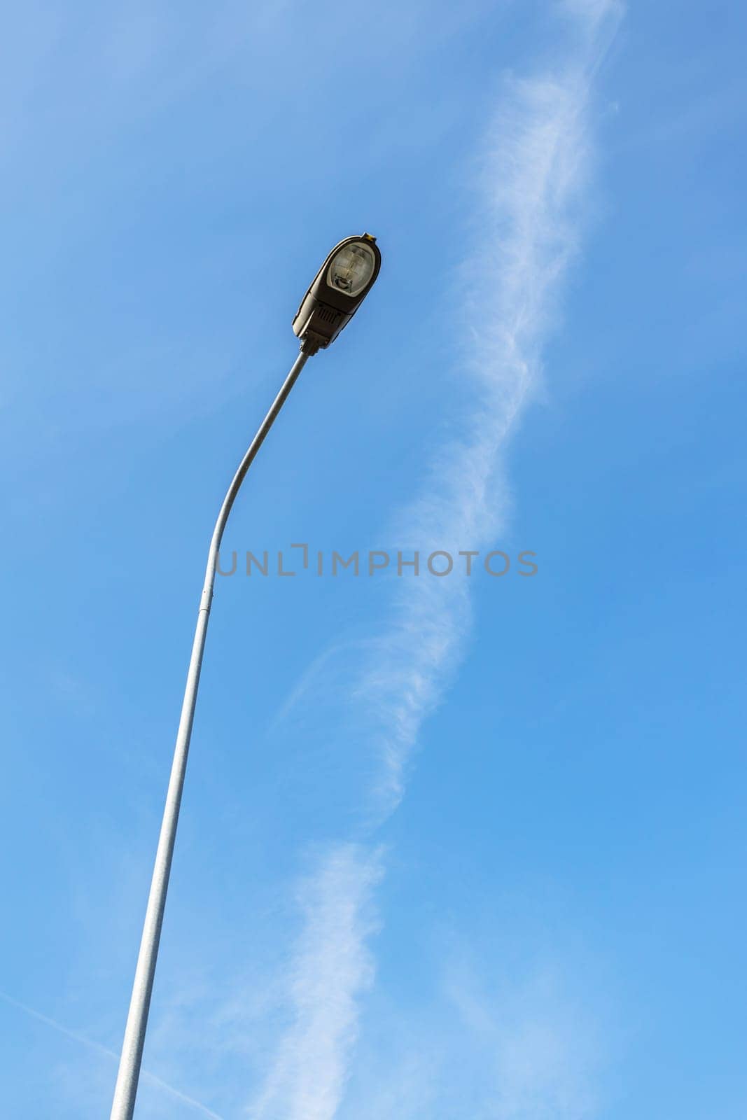 Modern street lamp against a blue sky. Bottom view.