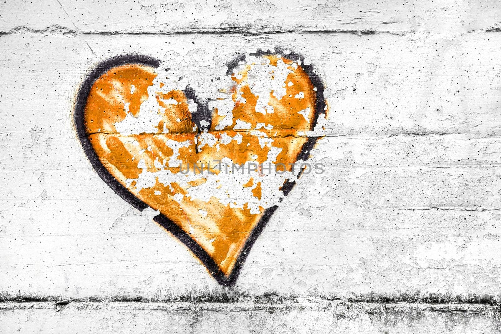 Painted orange abstract heart shape love symbol, dirty wall background, metaphor to urban and romantic valentine, grunge style.