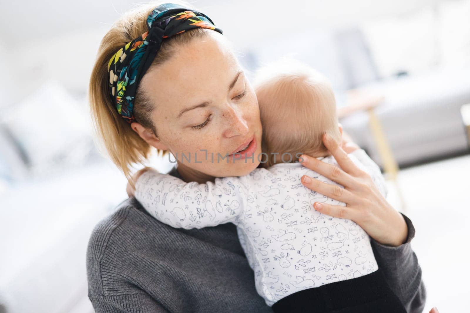 Tender woman caressing her little baby boy infant child at home. Mother's unconditional love for her child by kasto