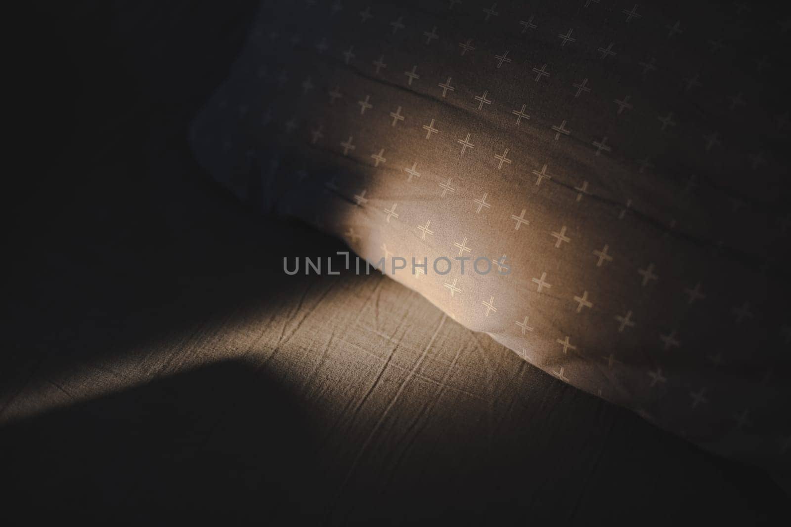 Rays of sun on empty bed, cozy early morning or getting up in the morning concept.
