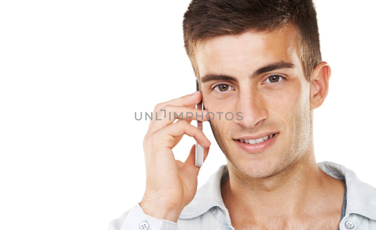 Communication through technology. A handsome male talking on his cell phone with a white background