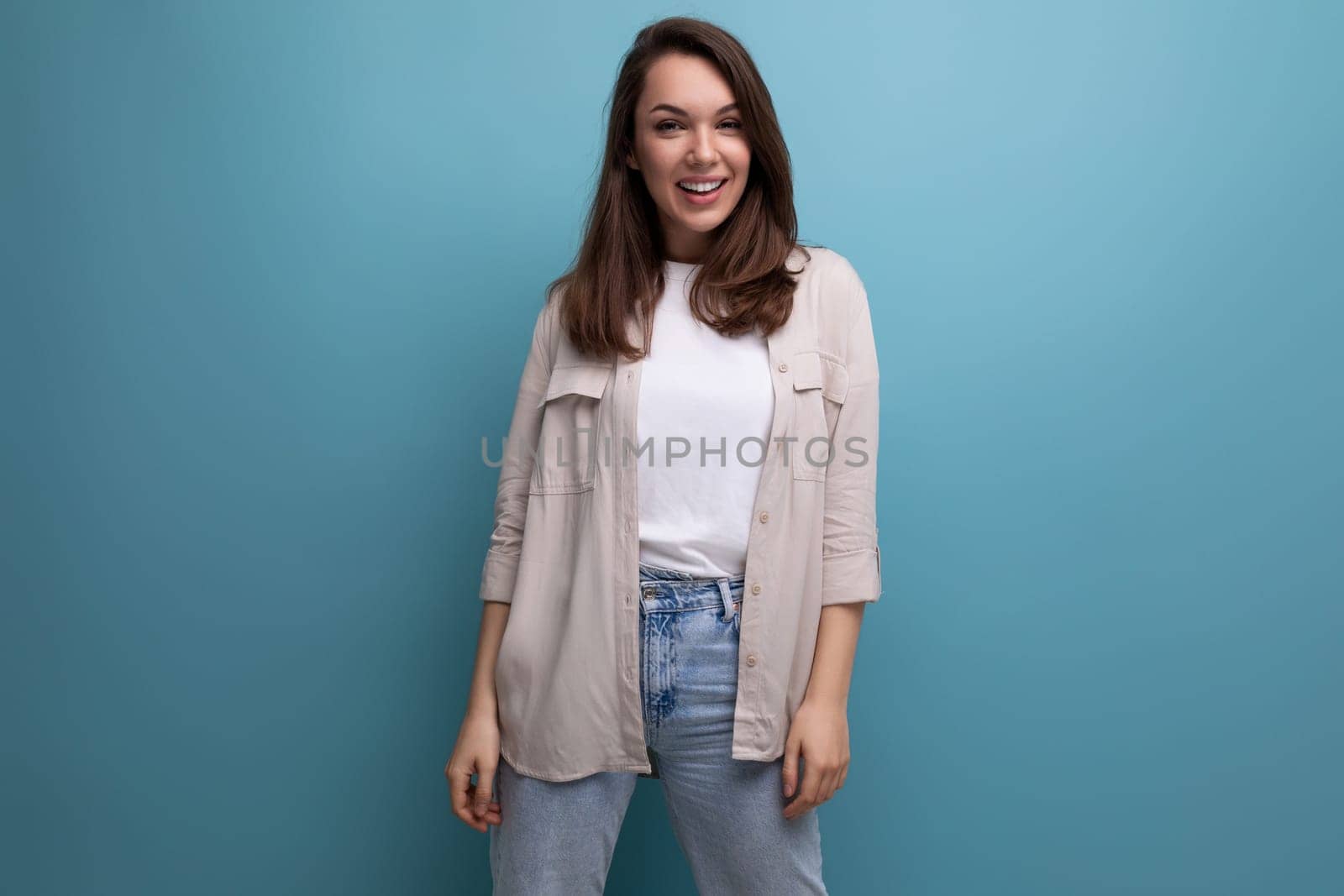 kind smiling 25 year old female person in an elegant casual look on a blue background.