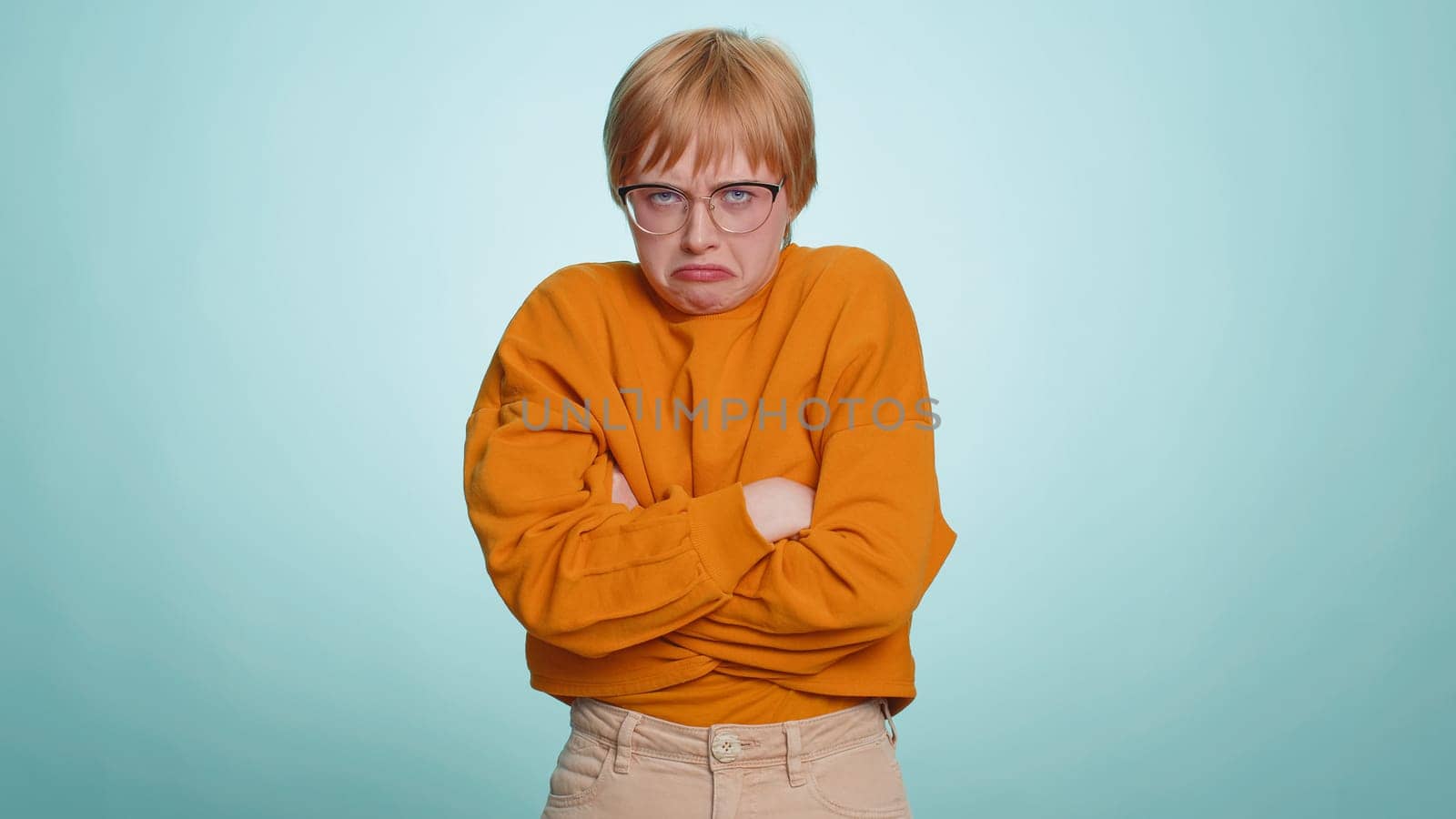 Offended sad nervous woman having misunderstanding, frustrated after quarrel, fail, lose, ignores and does not want to communicate, talk. Girl isolated on blue studio background. People lifestyle
