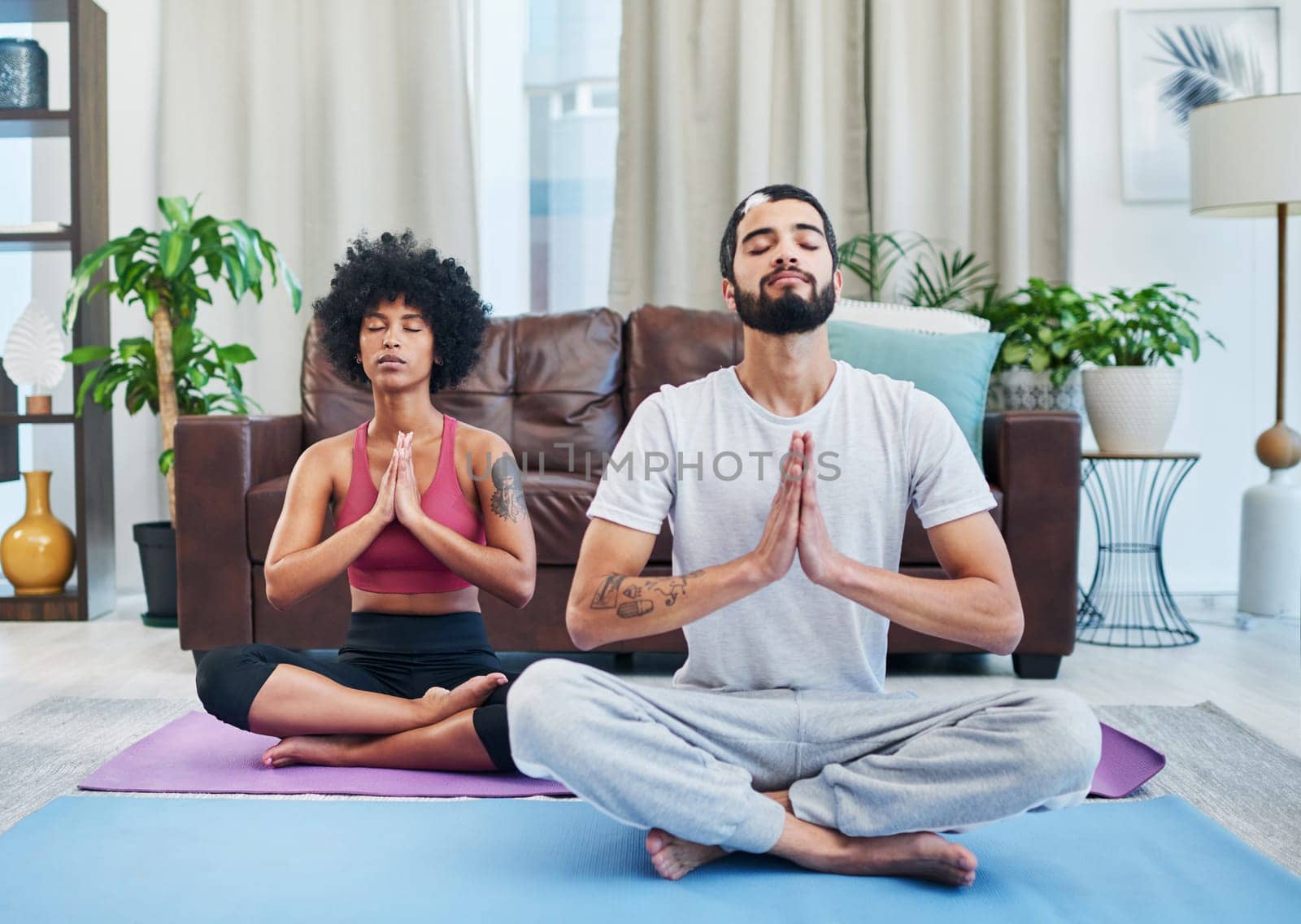 Yoga improved our health and our relationship. a young couple practising yoga in their living room. by YuriArcurs