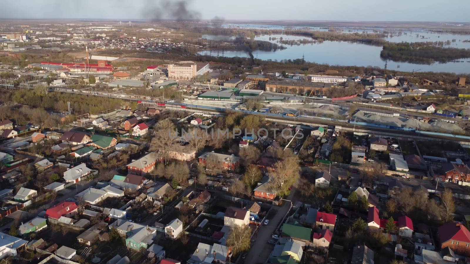 Cottage houses top view from a drone. Flight over the city. There is black smoke near the river. 4k