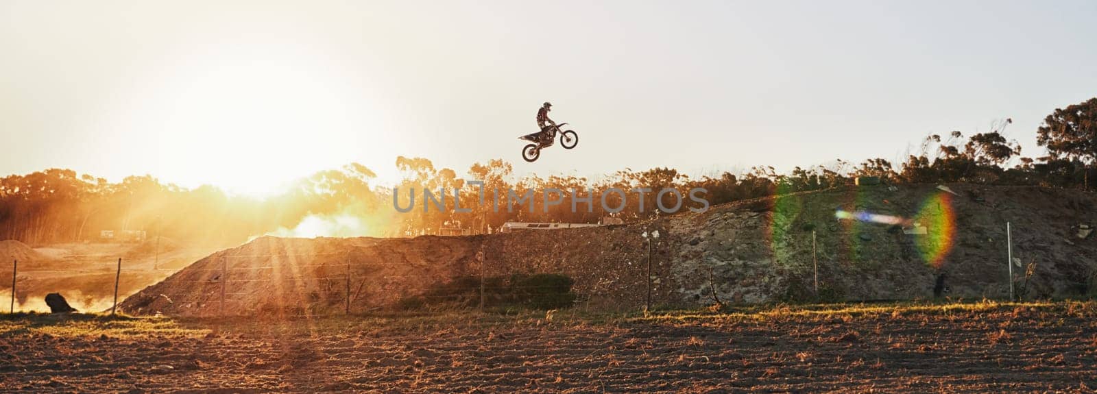 Going over every jump as if its the last. a motocross rider going over a jump during a race. by YuriArcurs