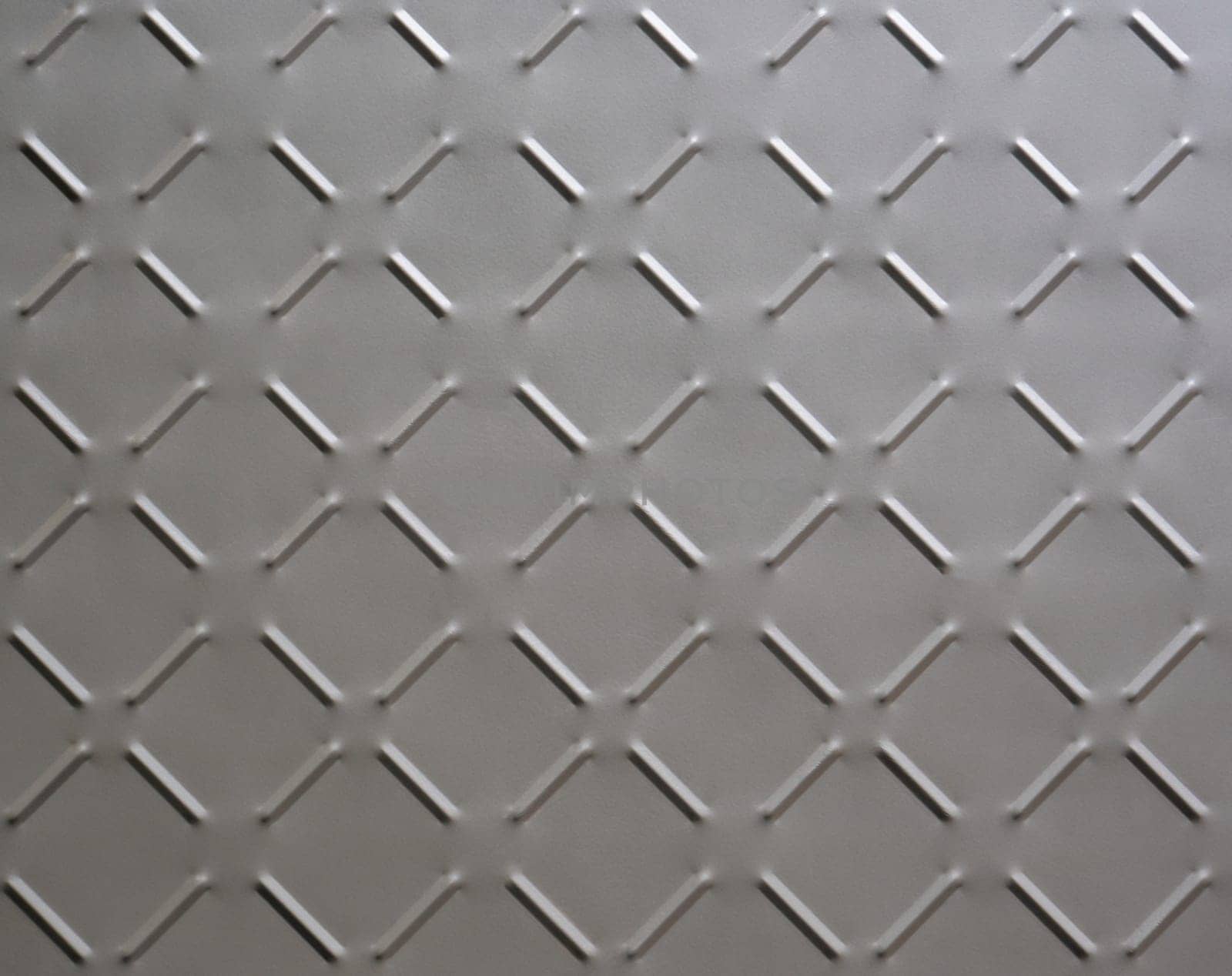 abstract background of metal plate with diamond pattern painted grey close up.