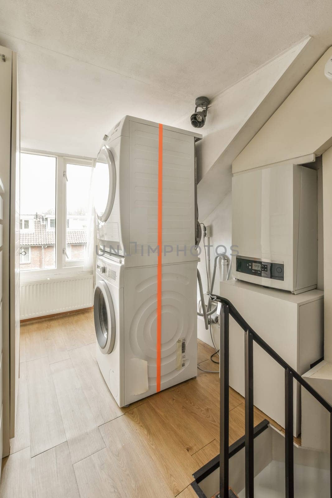 a washing machine in a living room with a window by casamedia