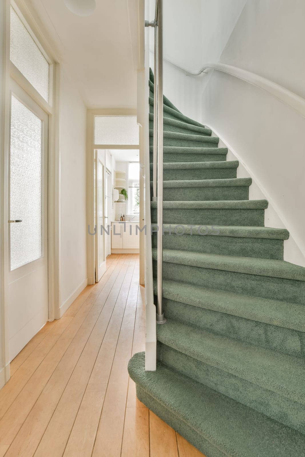 a staircase with green carpeted steps and white walls by casamedia