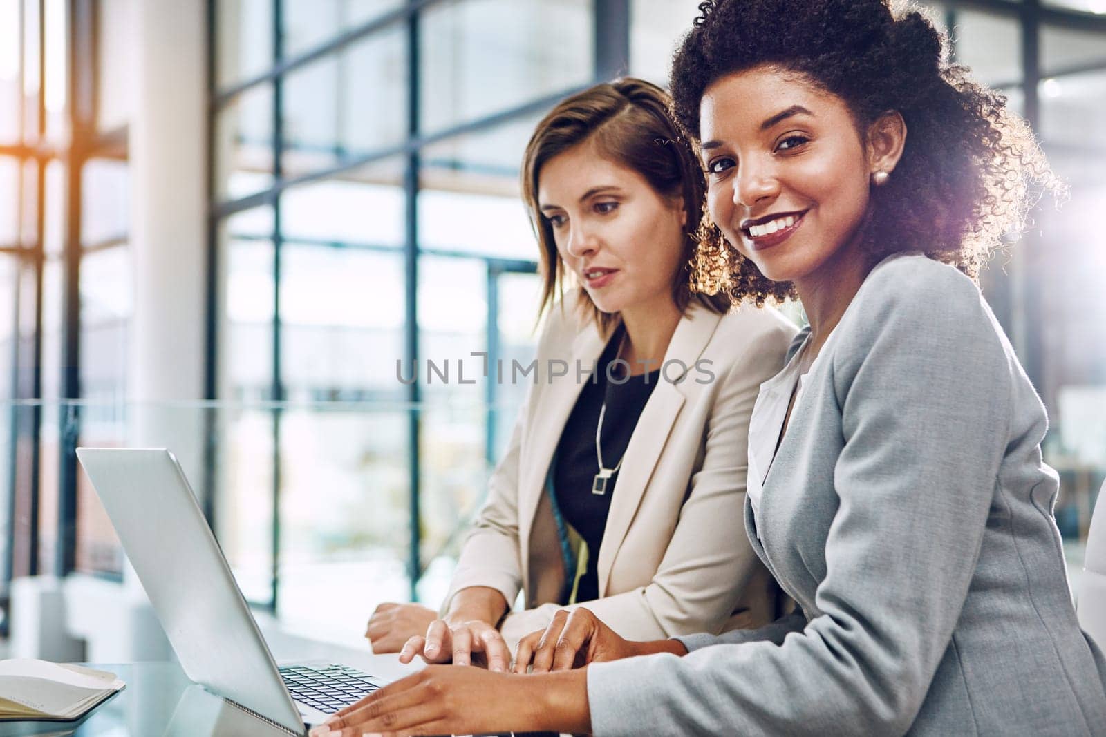 Business, businesswomen with laptop and at desk in modern office at work. Communication or conversation, portrait of friends or women colleagues and coworkers discussing or speaking in workplace.