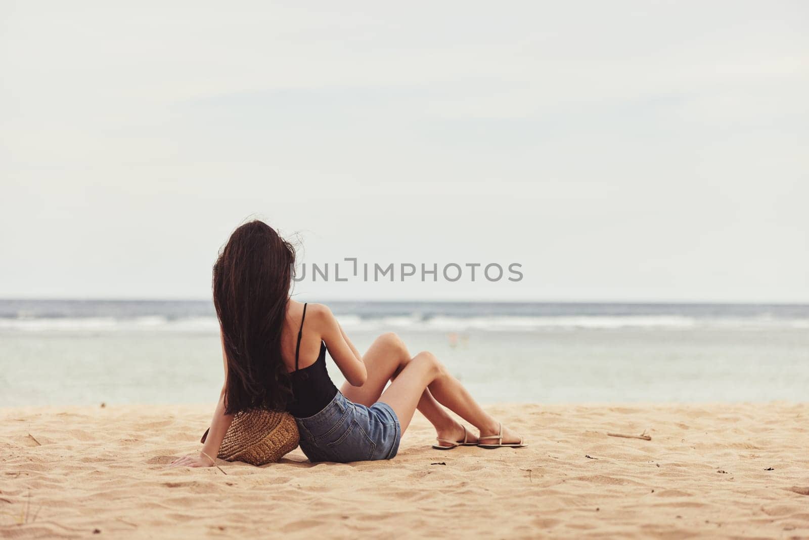 back woman vacation lifestyle sitting alone pretty sand fashion travel person nature freedom view body beauty sea white smile beach sun adult