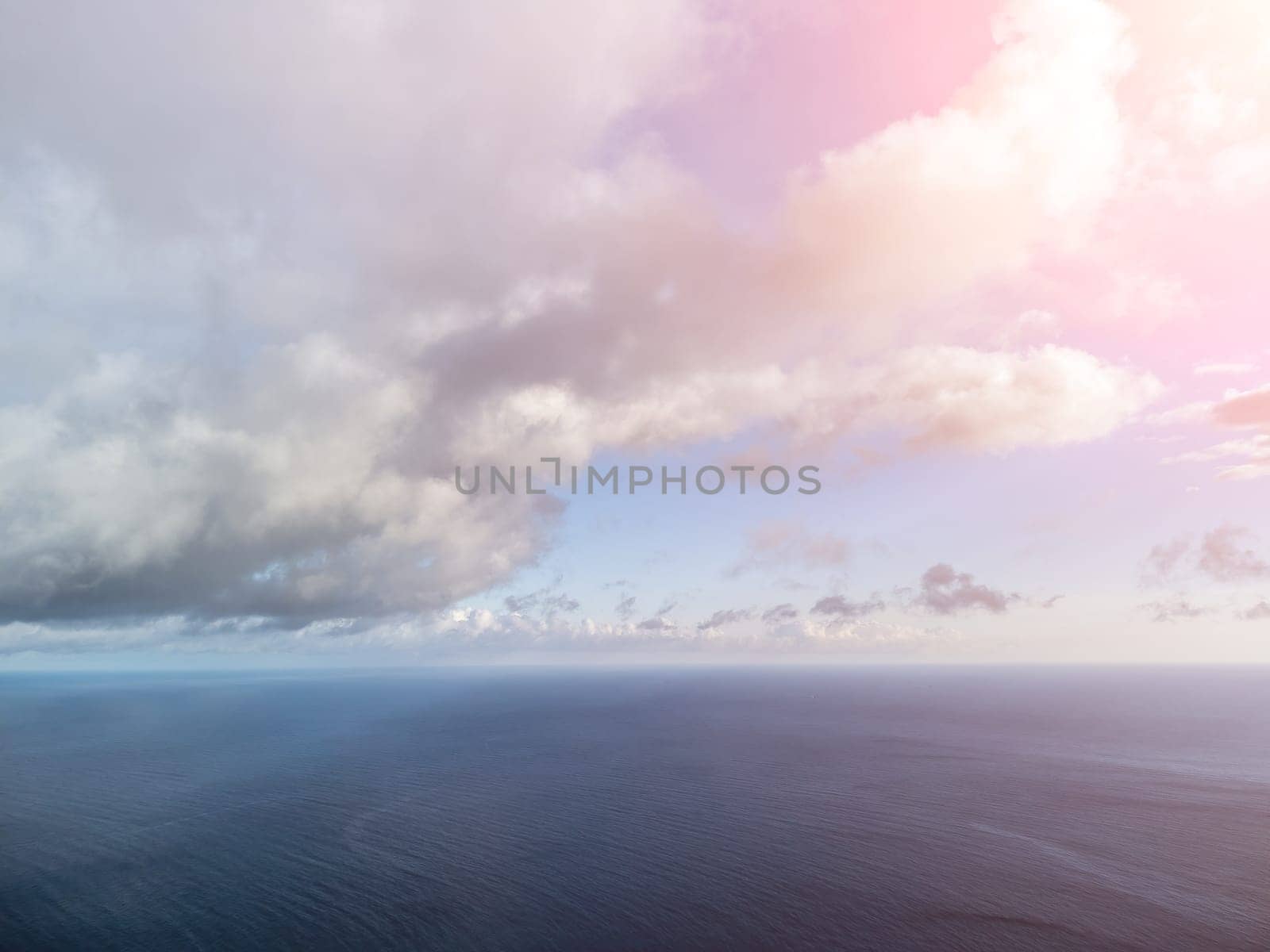 Aerial view. The drone flies over foggy and fluffy clouds. Blue sky sun and sea fog. Abstract aerial nature summer ocean sunset sea and sky background. Horizon. Vacation, travel and holiday concept by panophotograph