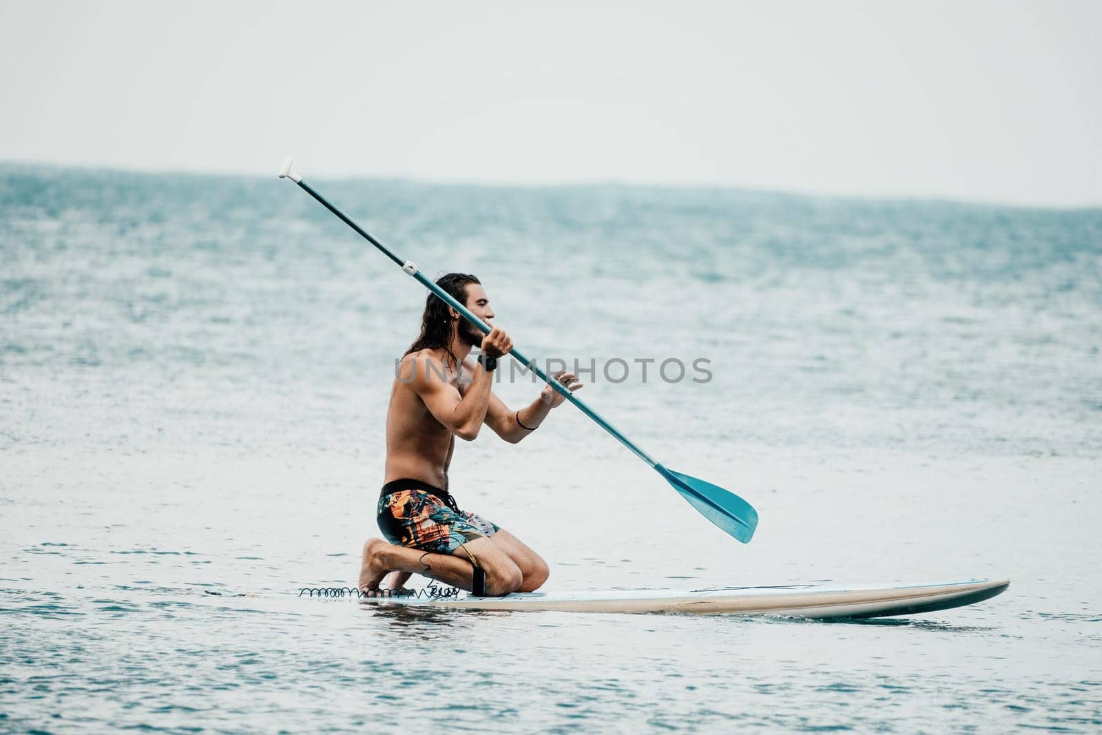 Sea woman and man on sup. Silhouette of happy young woman and man, surfing on SUP board, confident paddling through water surface. Idyllic sunset. Active lifestyle at sea or river