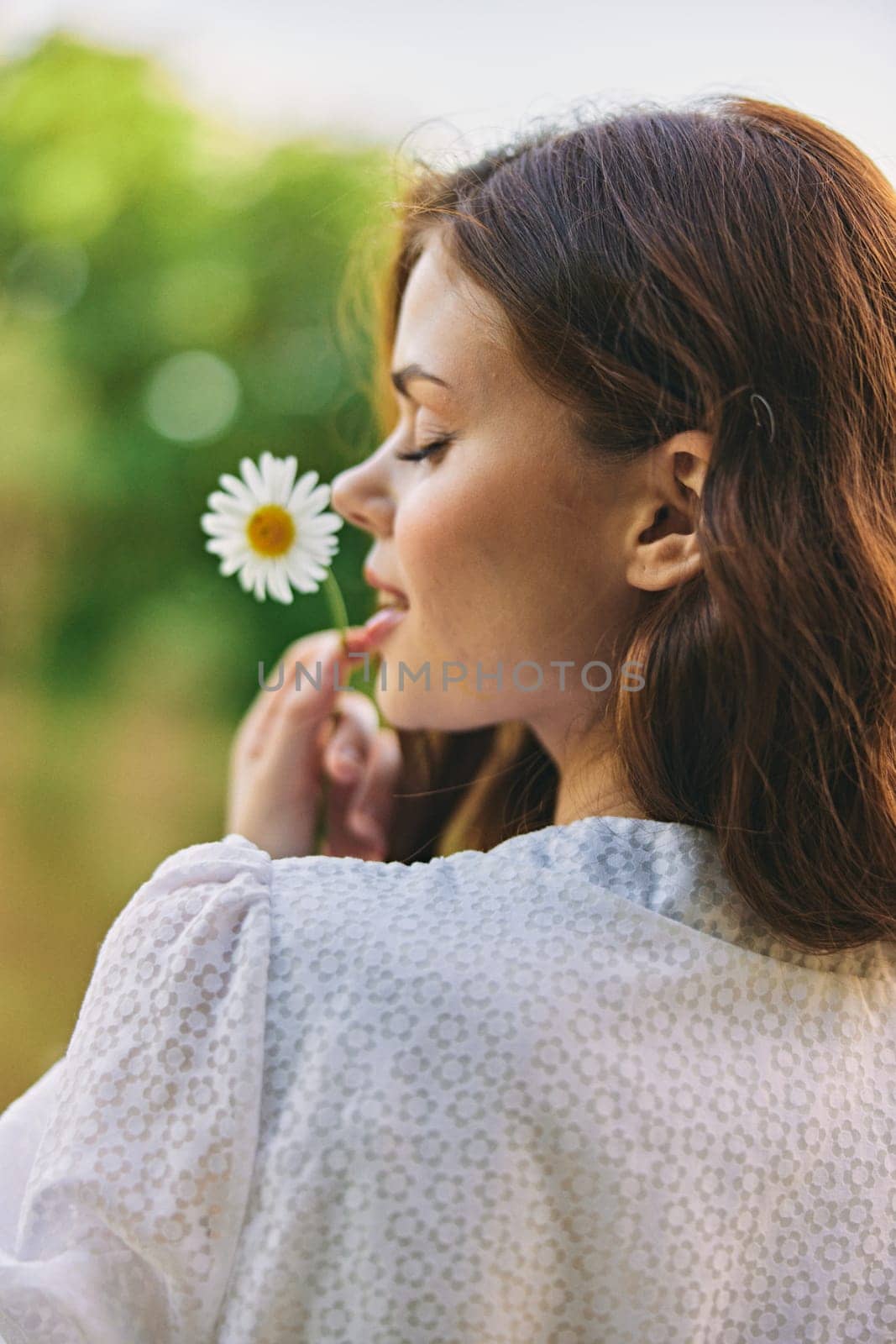 close-up portrait of a woman with a chamomile flower on the background of the lake by Vichizh