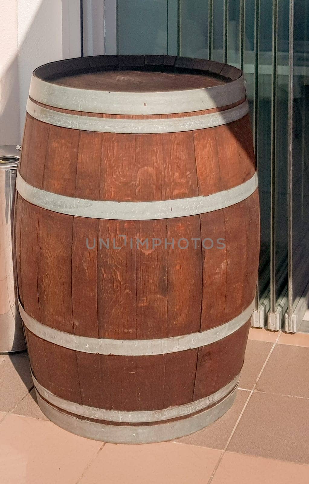 An old oak barrel stands at the entrance to a beer restaurant, shop, as an element of vintage design, vertical photo.