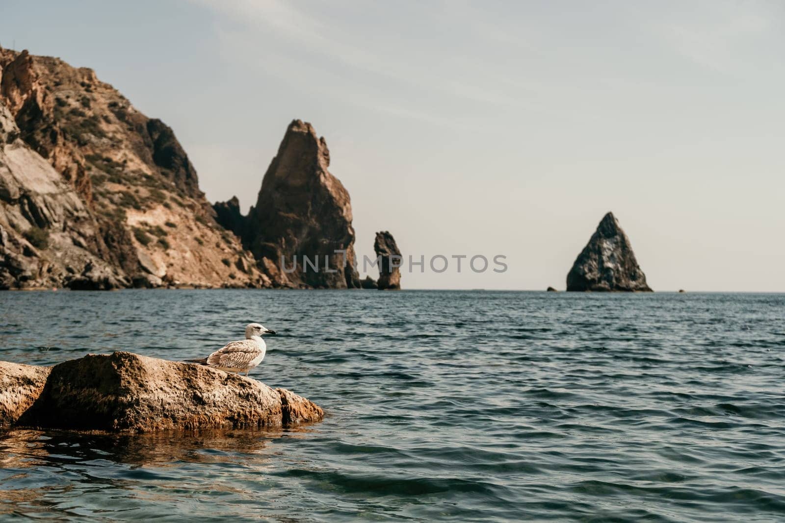 calm azure sea and volcanic rocky shores. Small waves on water surface in motion blur. Nature summer ocean sea beach background. Nobody. Holiday, vacation and travel concept by panophotograph