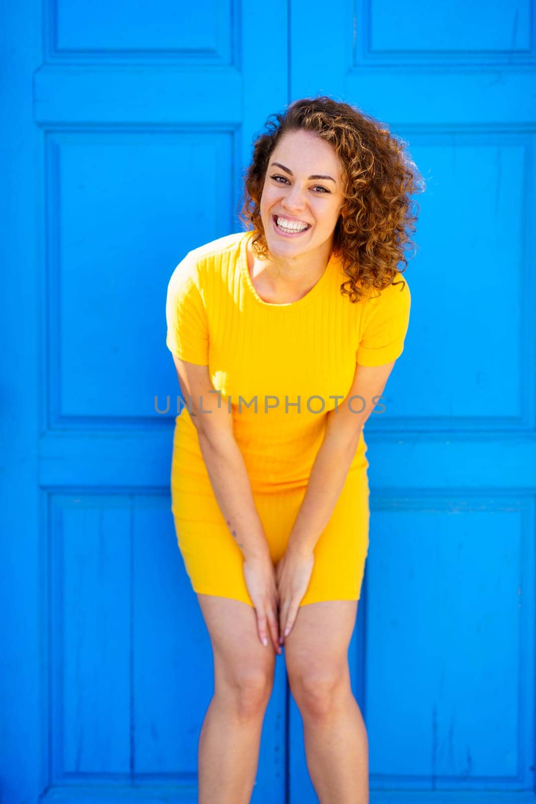 Cheerful woman smiling and looking at camera on street by javiindy