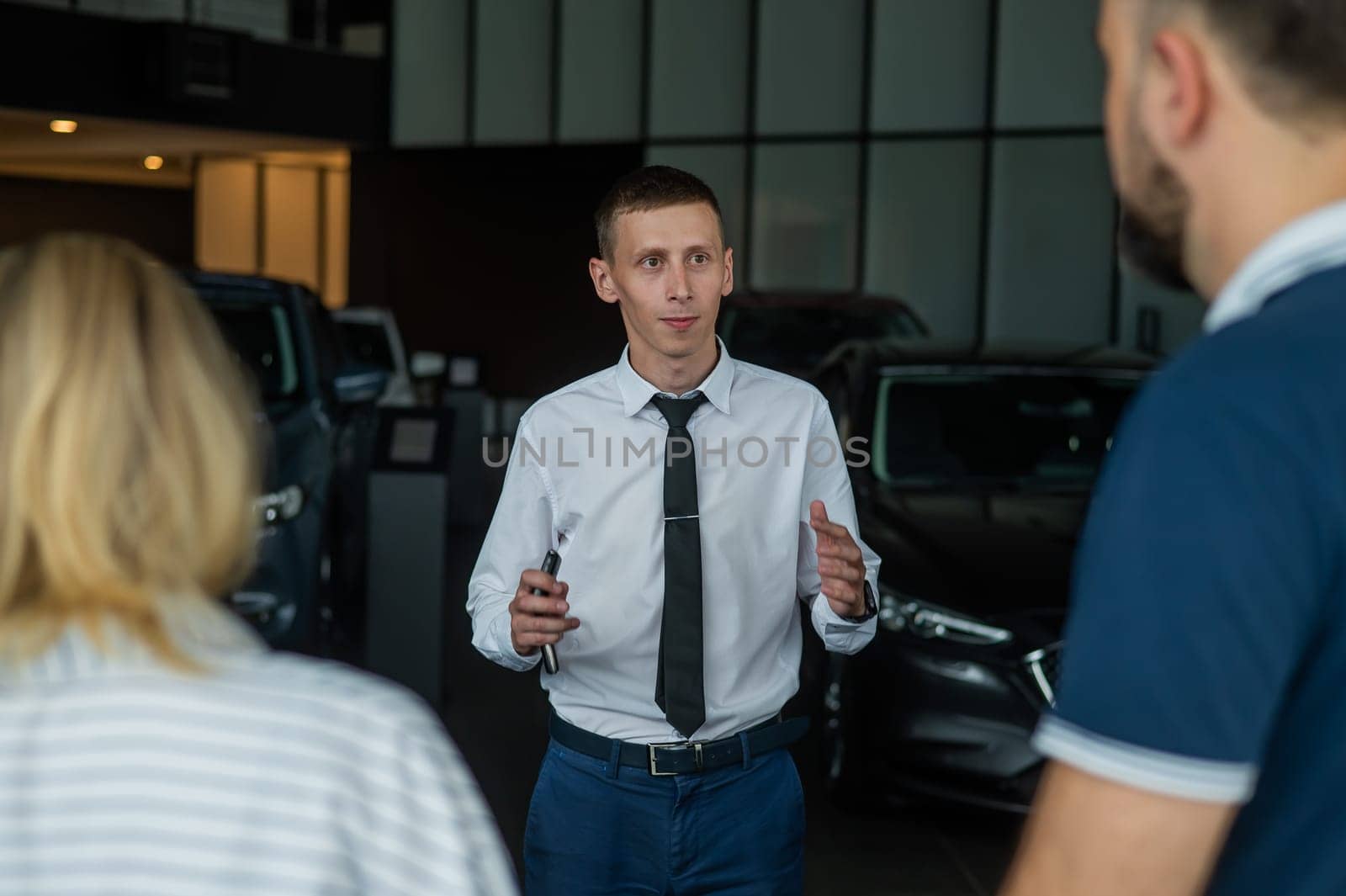 Happy caucasian couple choosing a new car in a car dealership