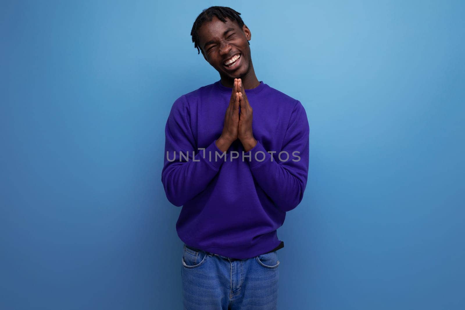 charming dark-skinned young brunette man with dreadlocks in a blue sweatshirt by TRMK