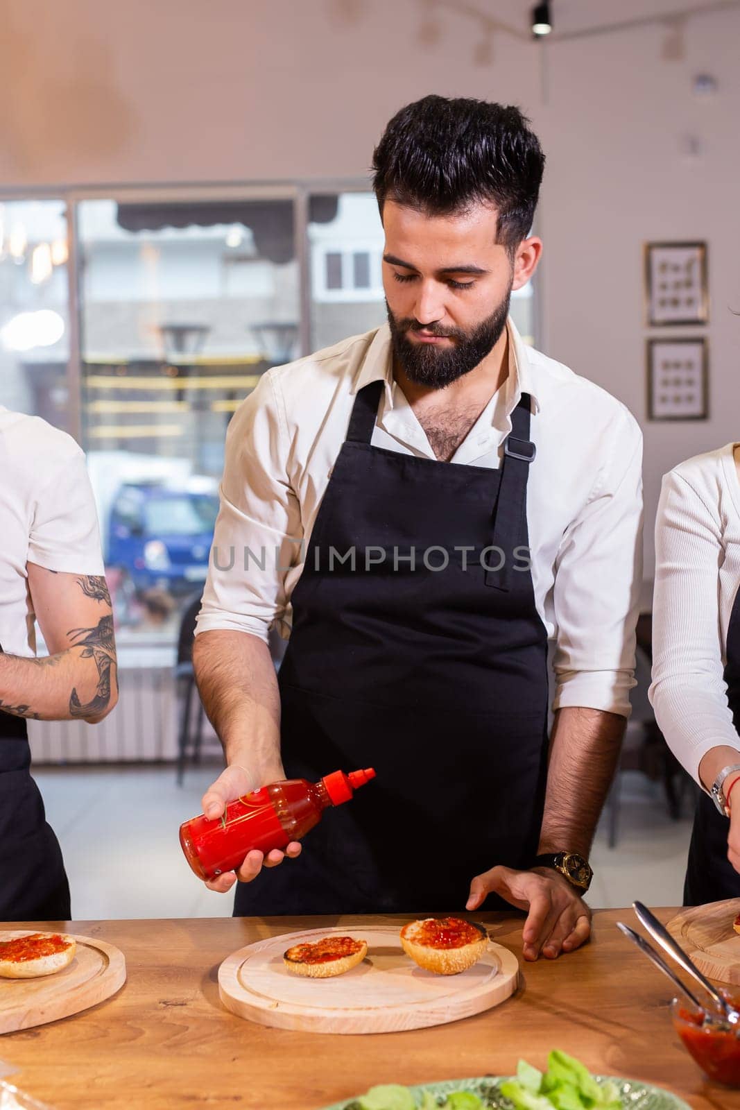 Chef pouring dressing over caprese salad in restaurant kitchen - food concept