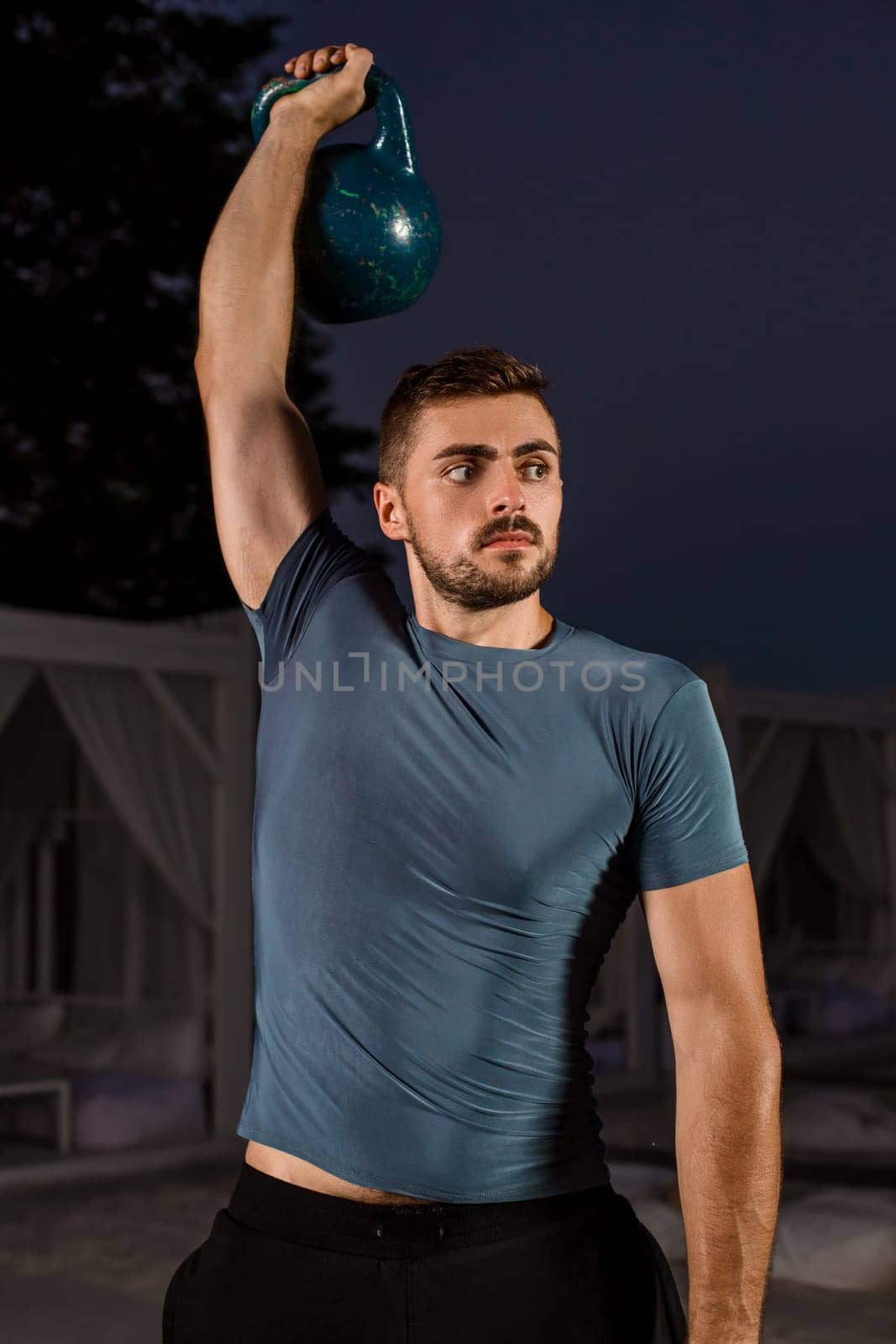 Muscular man working with weights at outdoor. sport exercises with kettlebell street workout