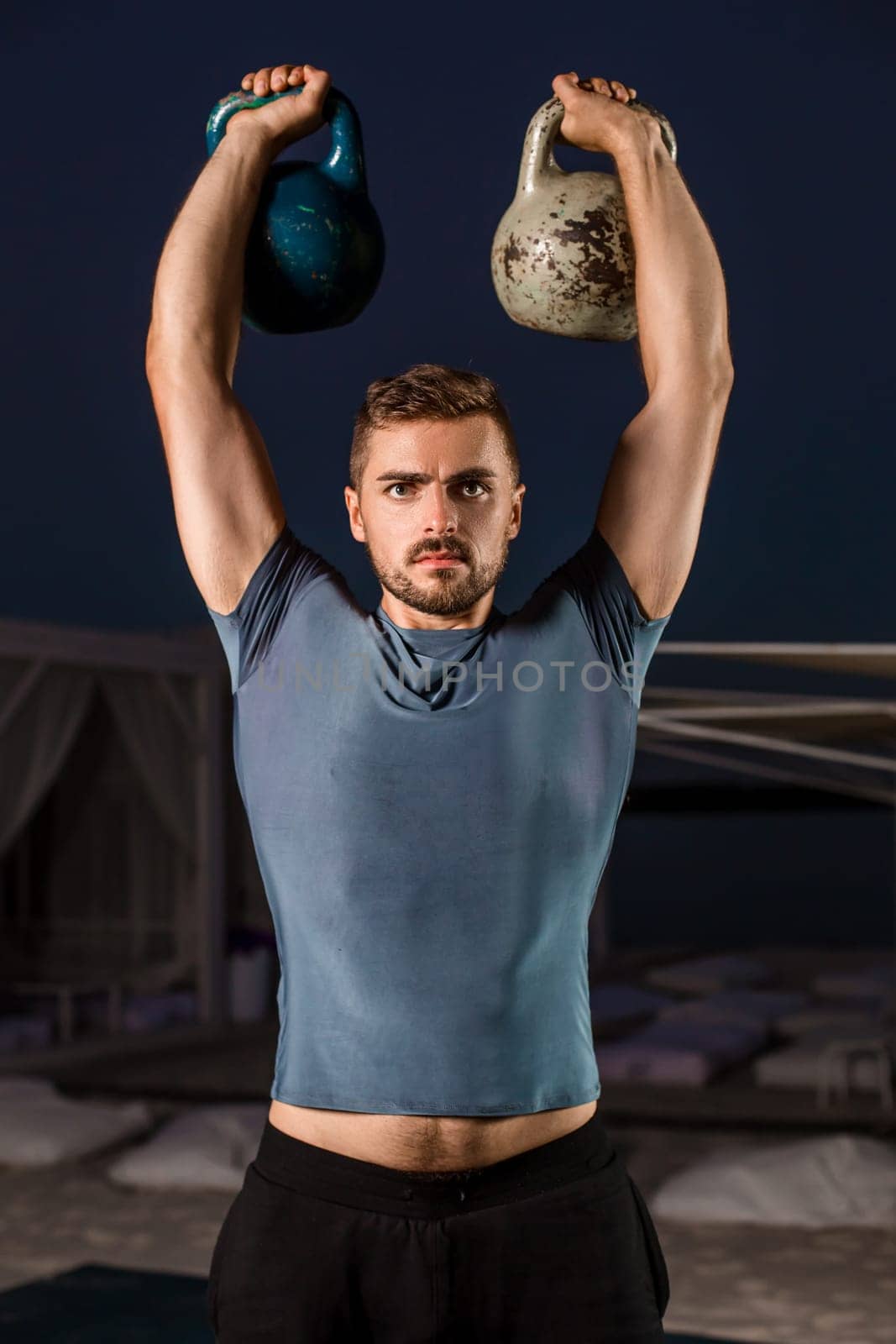 Muscular man working with weights at outdoor. sport exercises with kettlebell, street workout