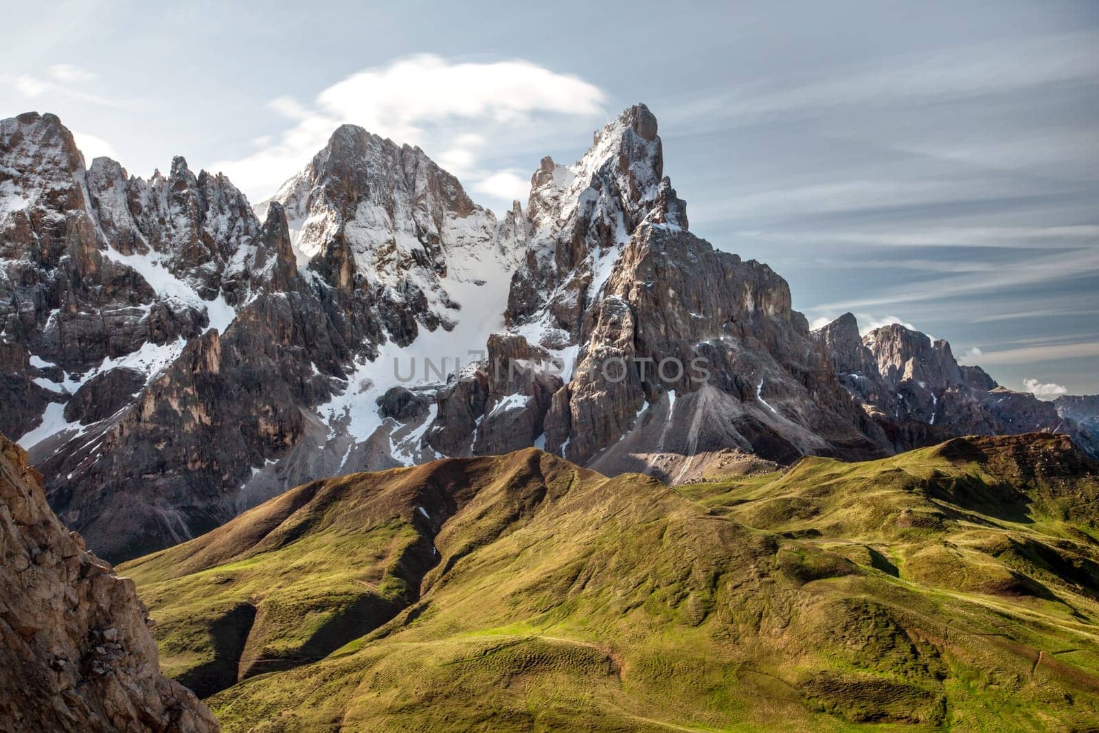 Cimon della Pala (also called "The Matterhorn of the Dolomites") with snow covered peaks grassy fields in foreground. San Martino di Castrozza, Italy.