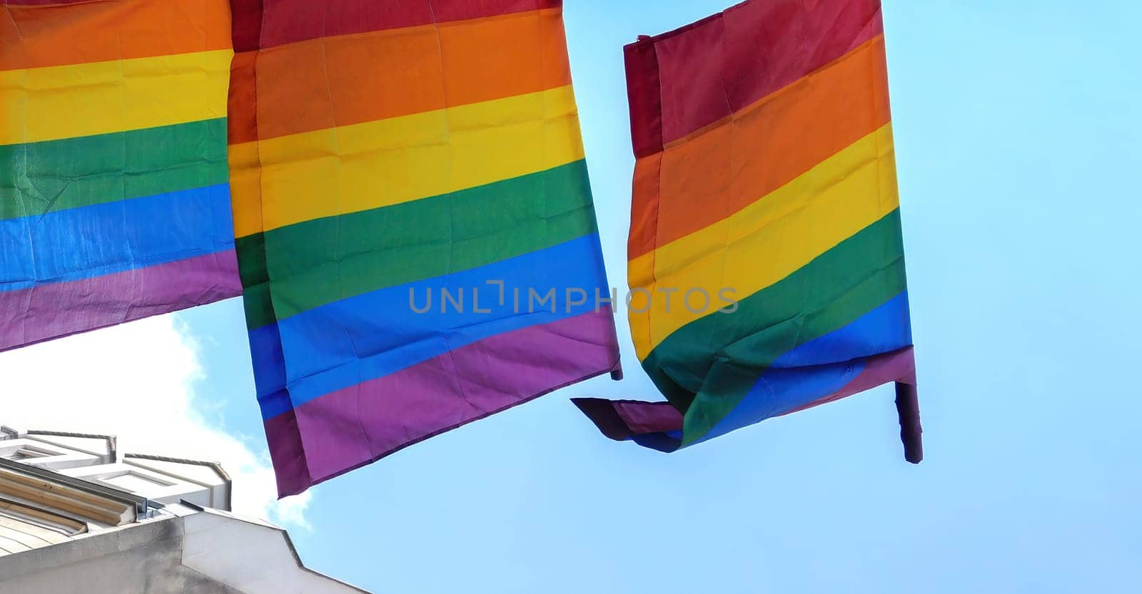 The rainbow flag, gay pride or LGBTQ symbol on light sky background by Whatawin