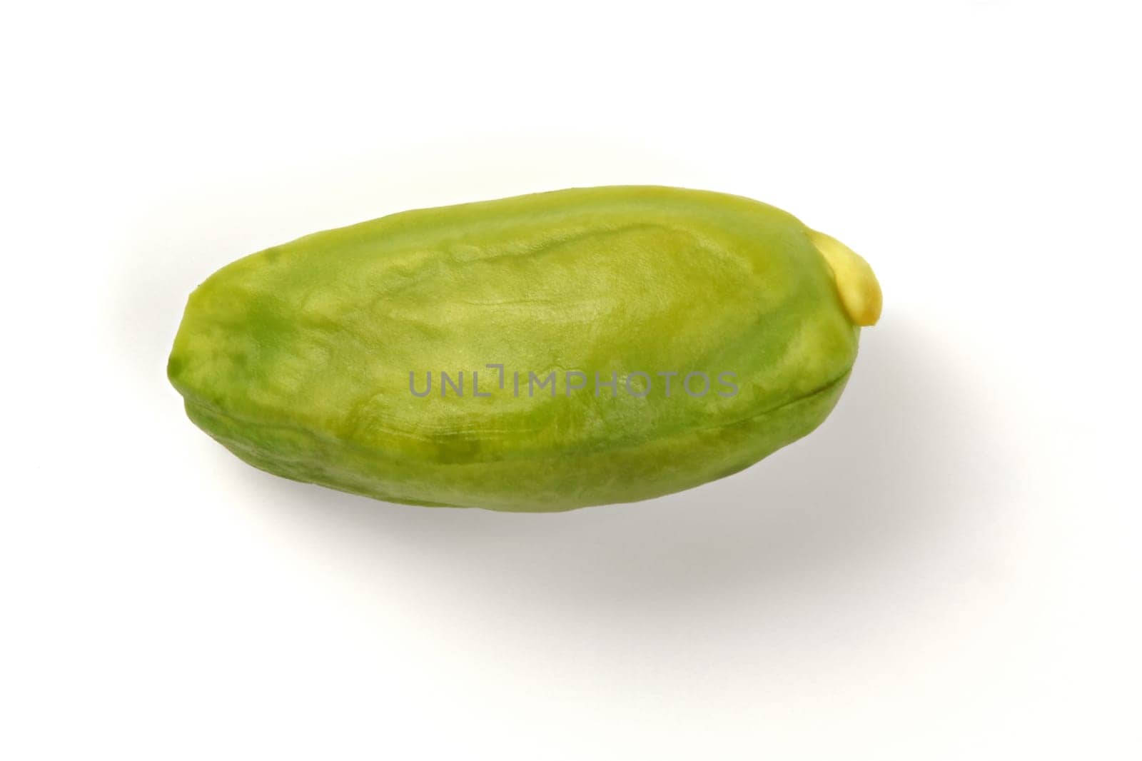 Single green pistachio nut peeled, isolated on white background.