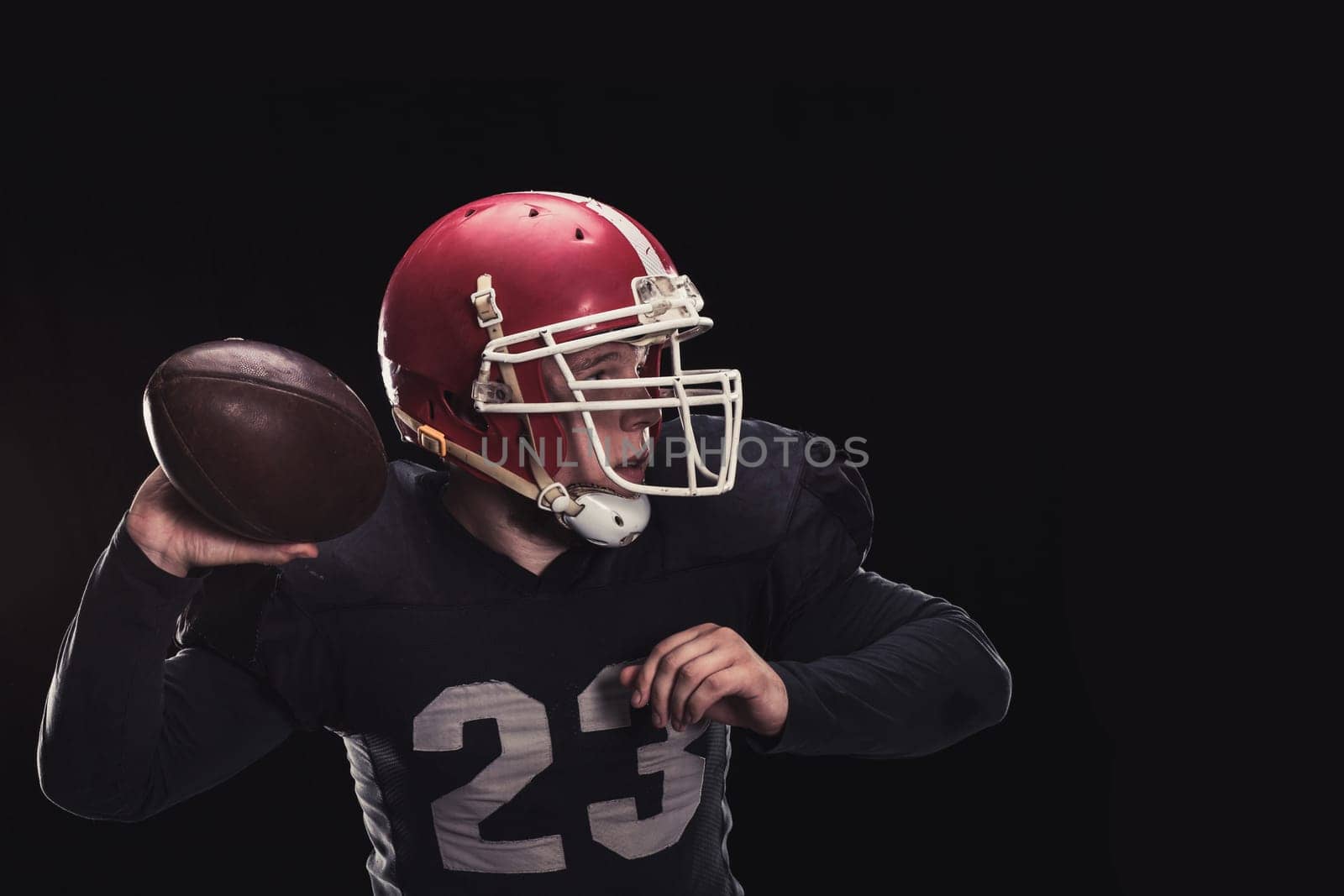 Soccer player on a dark background in vintage style. The classic American game. college Students. He makes the ball roll