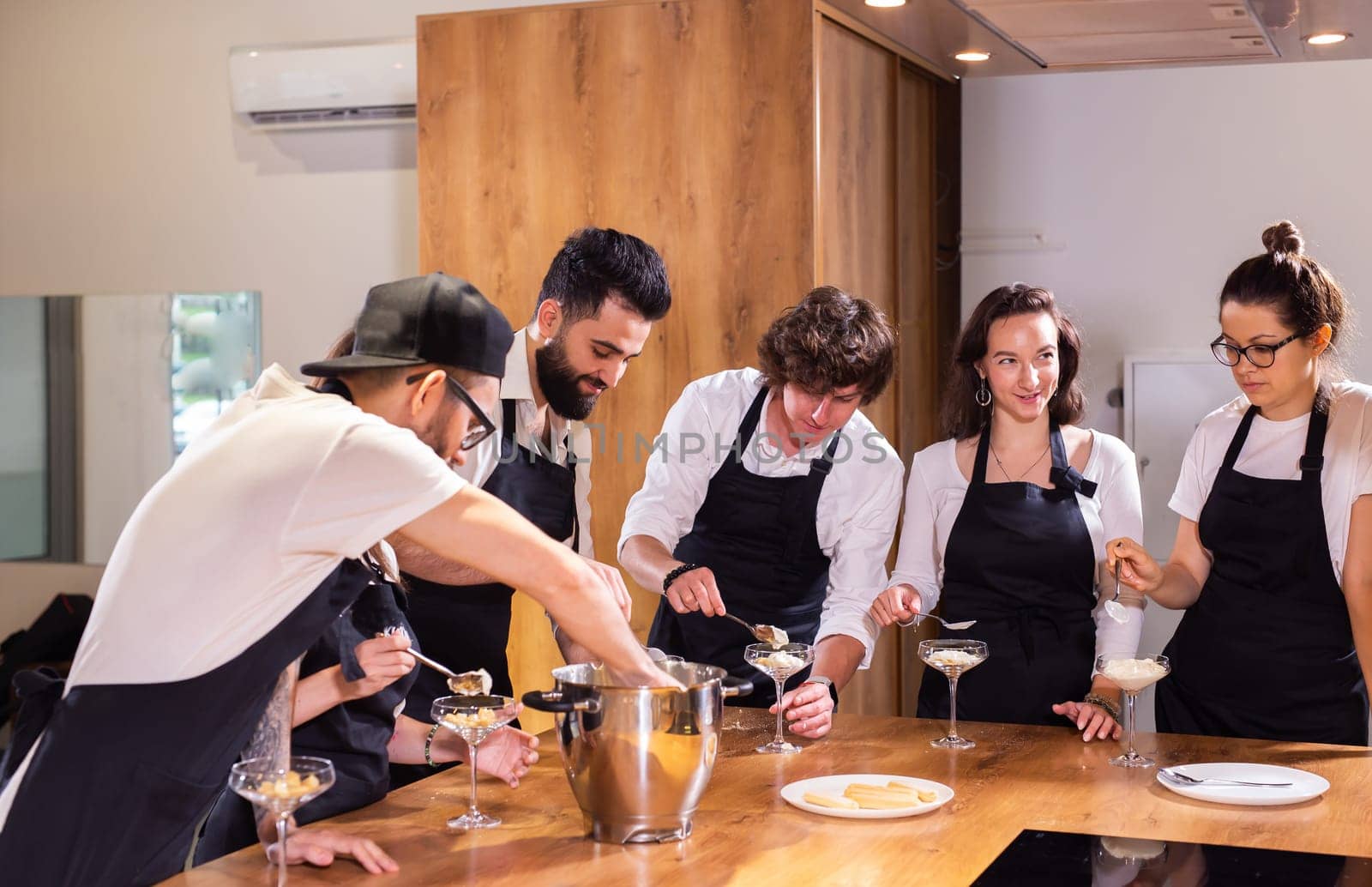 Chef teaching trainees how to make ice cream. Cooking tasty ice cream dessert made from chocolate and vanilla in glass bowl by Satura86